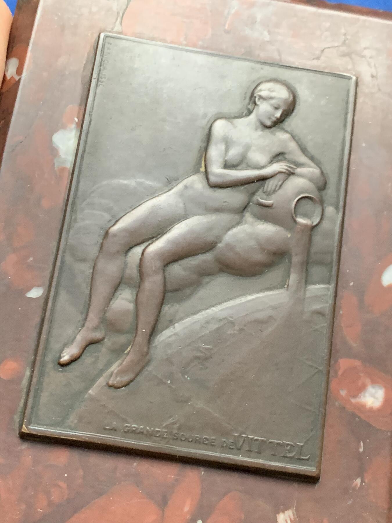 《竞宝斋》第464场 周日，周一，周二，3场连拍 （全场包邮）欢迎送拍 法国维泰勒温泉铜章 (La Grande Sourcede Vittel)嵌石桌面摆件 少见铜章 泉 法国新艺术时期美女清凉章 表现了一位半躺的女性裸体形象，倚靠在象征泉水出口的器形之上，身体姿态柔和，寓意泉水的滋养与生命力。607克，120x85.5x22mm，石板的角略有破损，细节见图。