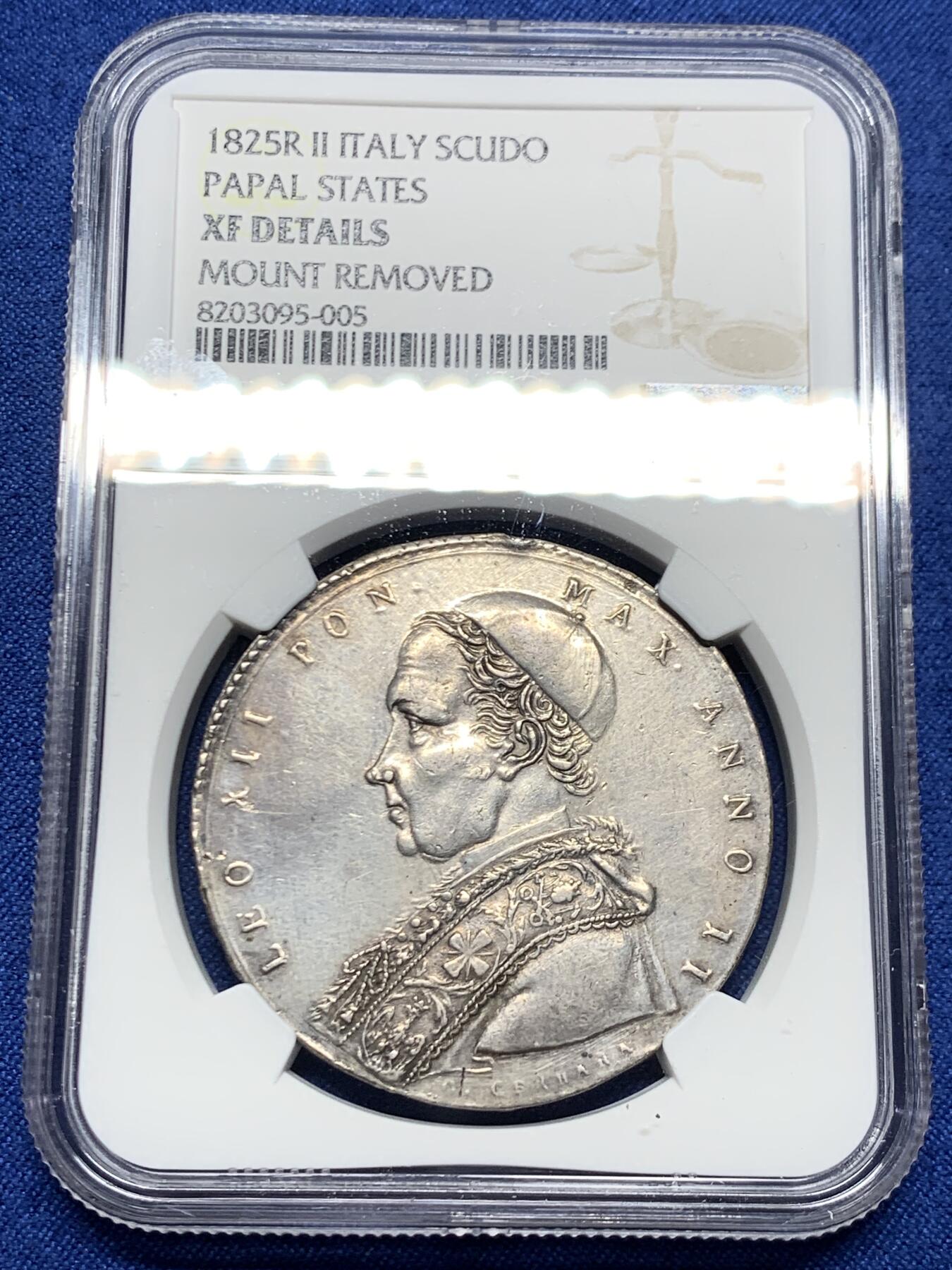 《竞宝斋》第464场 周日，周一，周二，3场连拍 （全场包邮）欢迎送拍 NGC XFD 意大利 教皇国 1825年 1斯库多 银币 精致的云端圣母题材 12点钟有一处微小的镶嵌移除痕迹 这枚的圣母头饰不同于克书版 是略弯曲的 不清楚在稀有度上是否有区别 很少见的品种