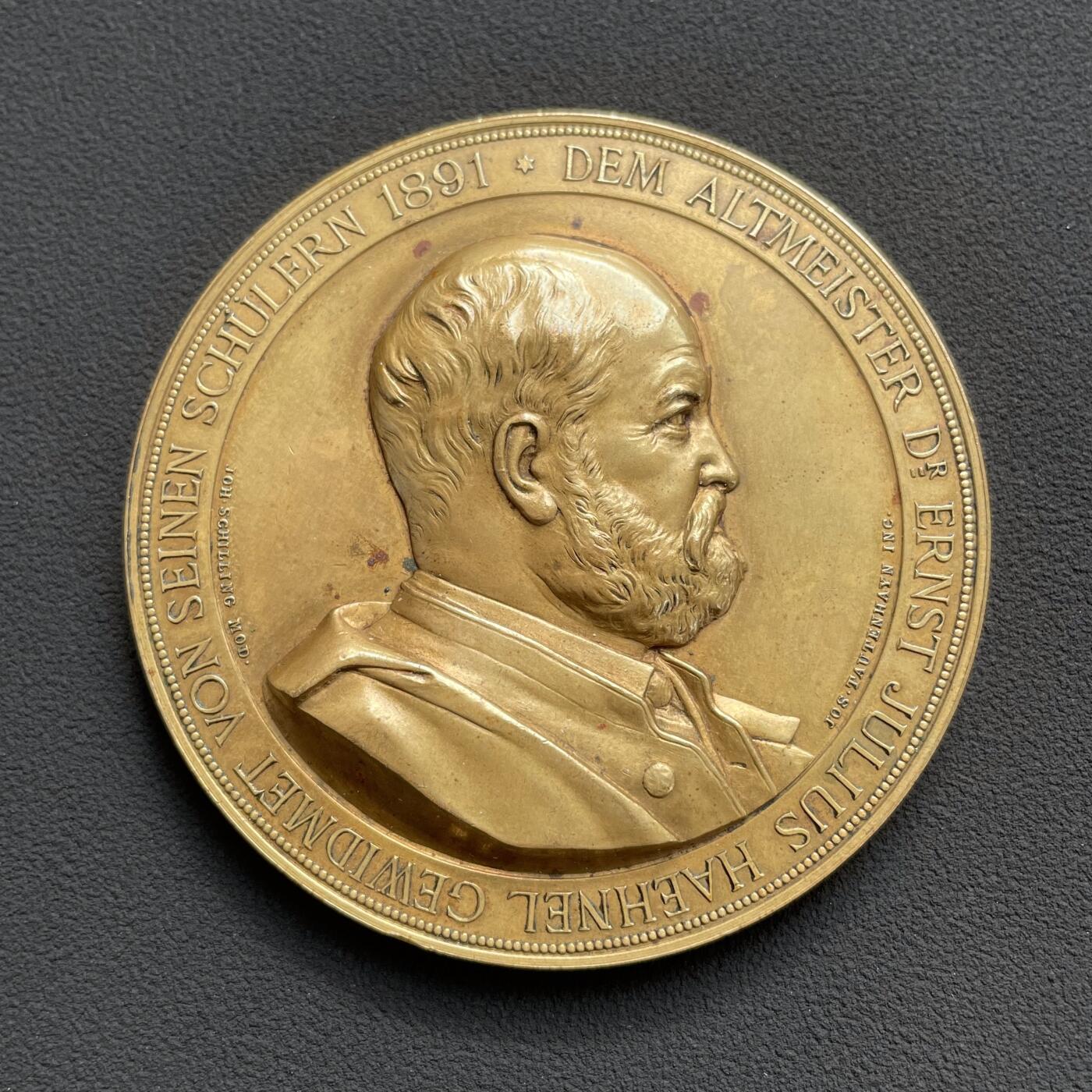 「木头集藏」“ 新岁撷珍”——章牌精品专场！   J. Tautenhayn～1891年德国 雕塑家黑内尔逝世纪念镀金铜章，直径：63 mm，112 g，罕见品种！由德国雕塑家席林和奥地利章牌大师陶滕海因联袂制作。正面是黑内尔肖像，背面半裸女神拨动琴弦，身下狮身人面的形象非常惊艳，兼具成熟女性的魅力与野兽的矫健。  恩斯特·尤利乌斯·黑内尔（1811-1891年）是19世纪德国最负盛名的雕塑家之一。