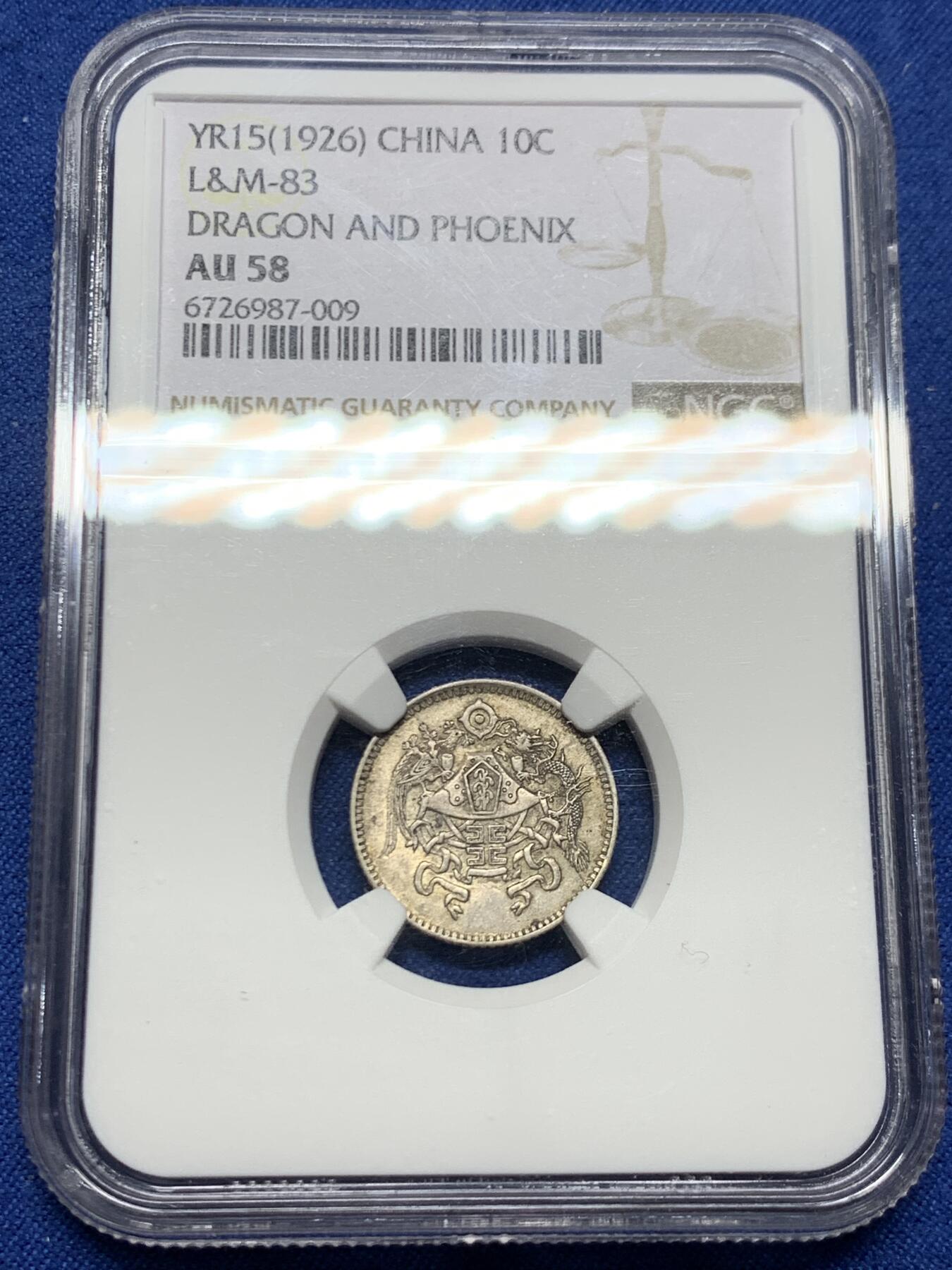 《竞宝斋》第464场 周日，周一，周二，3场连拍 （全场包邮）欢迎送拍 NGC AU58 龙凤壹角 中华民国十五年十二章龙凤黼黻嘉禾壹角银币 原状态好彩老味道，未下过水，淡金彩很好看。十二章国徽是民国13年至民国28年间北洋政府时期的国徽，图案取材自「日、月、星、辰、山、龙、华虫、宗彝、藻、粉米、黼、黻」十二章纹，由鲁迅、许寿裳、钱稻荪研拟。