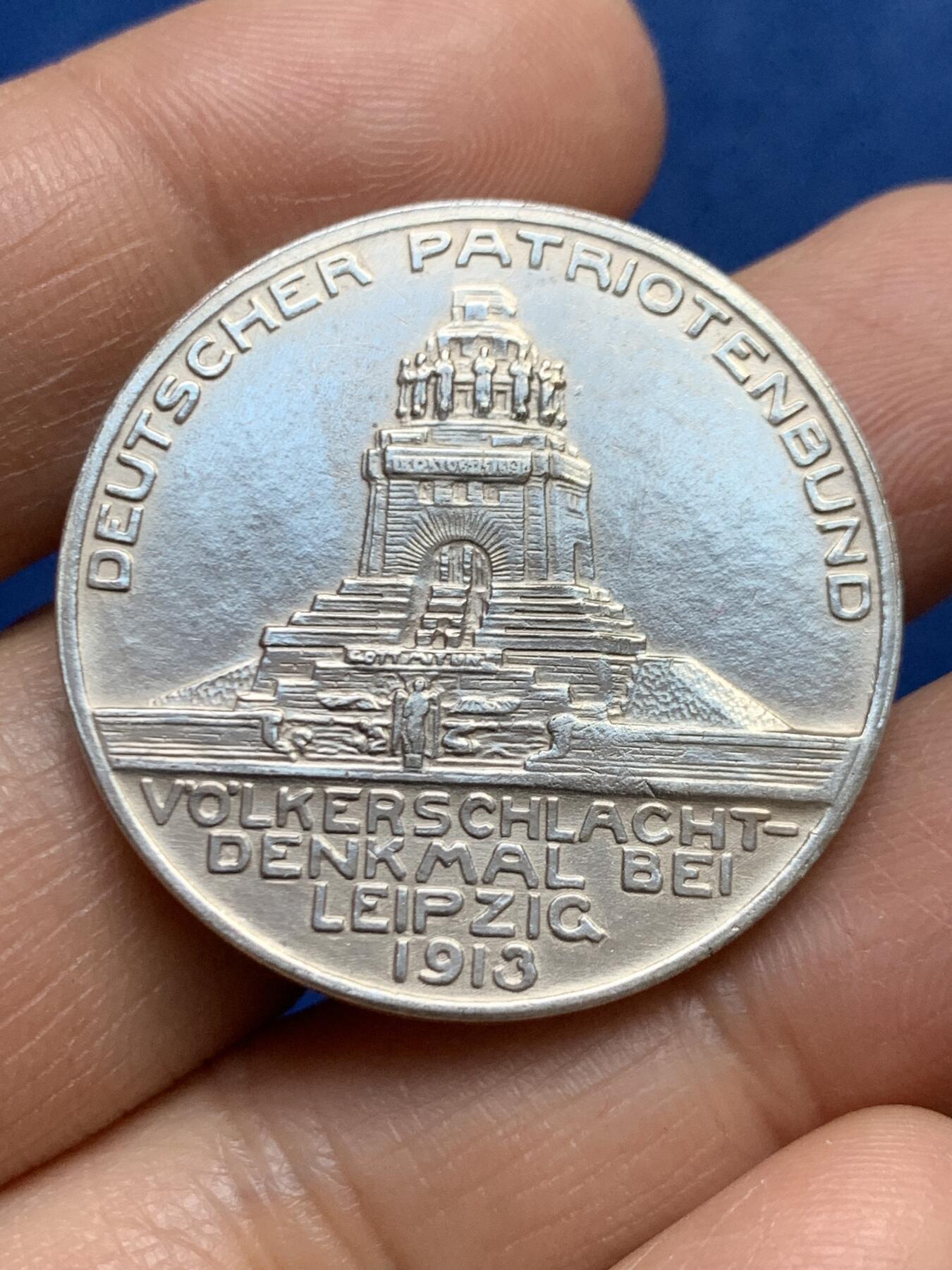 《竞宝斋》第465场 周日，周一，周二，3场连拍 （全场包邮）欢迎送拍 德国1913年莱比锡大会战镀银纪念章，莱比锡战役是拿破仑战争中的决定性战役，又称莱比锡各民族大会战。重约：17.1克 直径约：33mm 正面三鹰战一鹰象征反法联盟的胜利，背面莱比锡建功碑。
