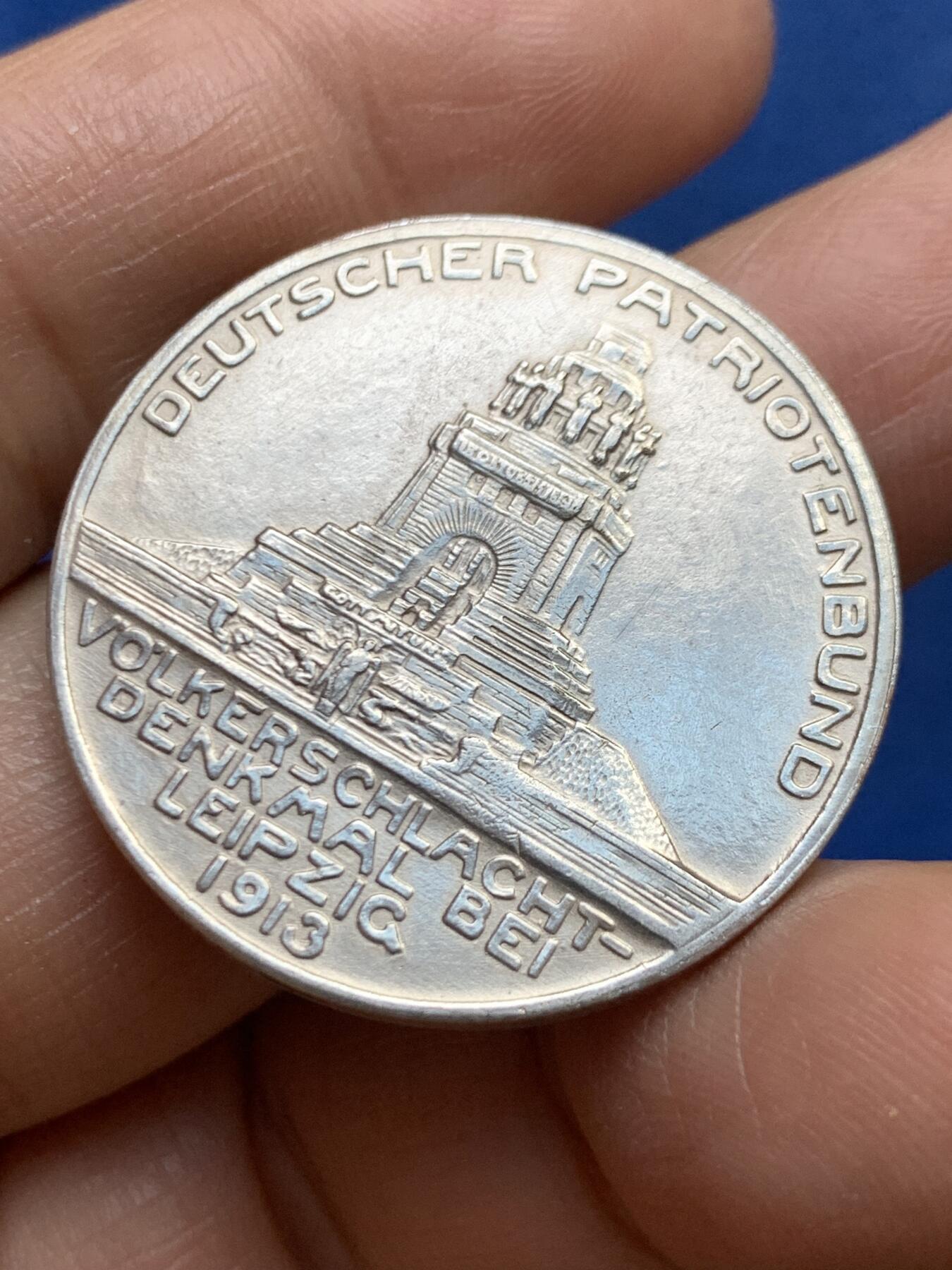 《竞宝斋》第465场 周日，周一，周二，3场连拍 （全场包邮）欢迎送拍 德国1913年莱比锡大会战镀银纪念章，莱比锡战役是拿破仑战争中的决定性战役，又称莱比锡各民族大会战。重约：17.1克 直径约：33mm 正面三鹰战一鹰象征反法联盟的胜利，背面莱比锡建功碑。