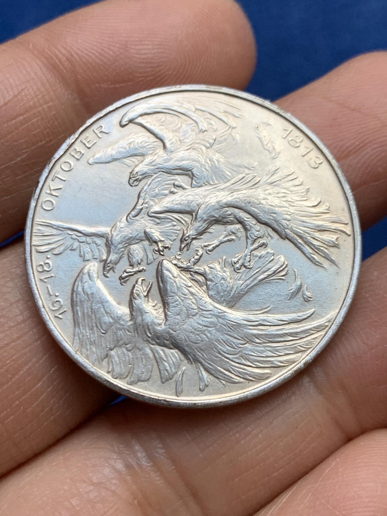 《竞宝斋》第465场 周日，周一，周二，3场连拍 （全场包邮）欢迎送拍 德国1913年莱比锡大会战镀银纪念章，莱比锡战役是拿破仑战争中的决定性战役，又称莱比锡各民族大会战。重约：17.1克 直径约：33mm 正面三鹰战一鹰象征反法联盟的胜利，背面莱比锡建功碑。