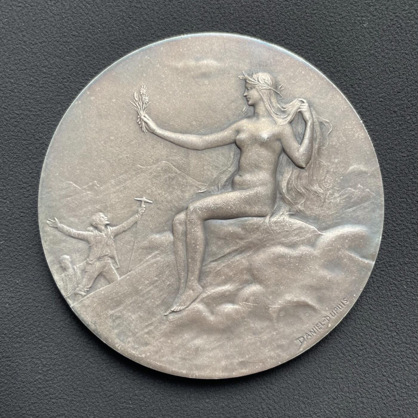 「木头集藏」“ 新岁撷珍”——章牌精品专场！ D.Dupuis～法国阿尔卑斯登山俱乐部大银章，直径: 64mm，124.5 g，  边铭: 丰饶角1ARGENT ，法国阿尔卑斯登山俱乐部赠乔治·布贝先生，正面：头戴桂冠的女神坐在云层上的高山之巅，手持一束阿尔卑斯山的名花——雪绒花，向张开双臂欢呼胜利登顶的登山者们致以欢迎之意。背面：饰以棕榈枝、登山杖、登山镐和绳索的羊皮纸题笺。 边缘一处很轻微的锉痕。少见银章，上手感觉更佳！