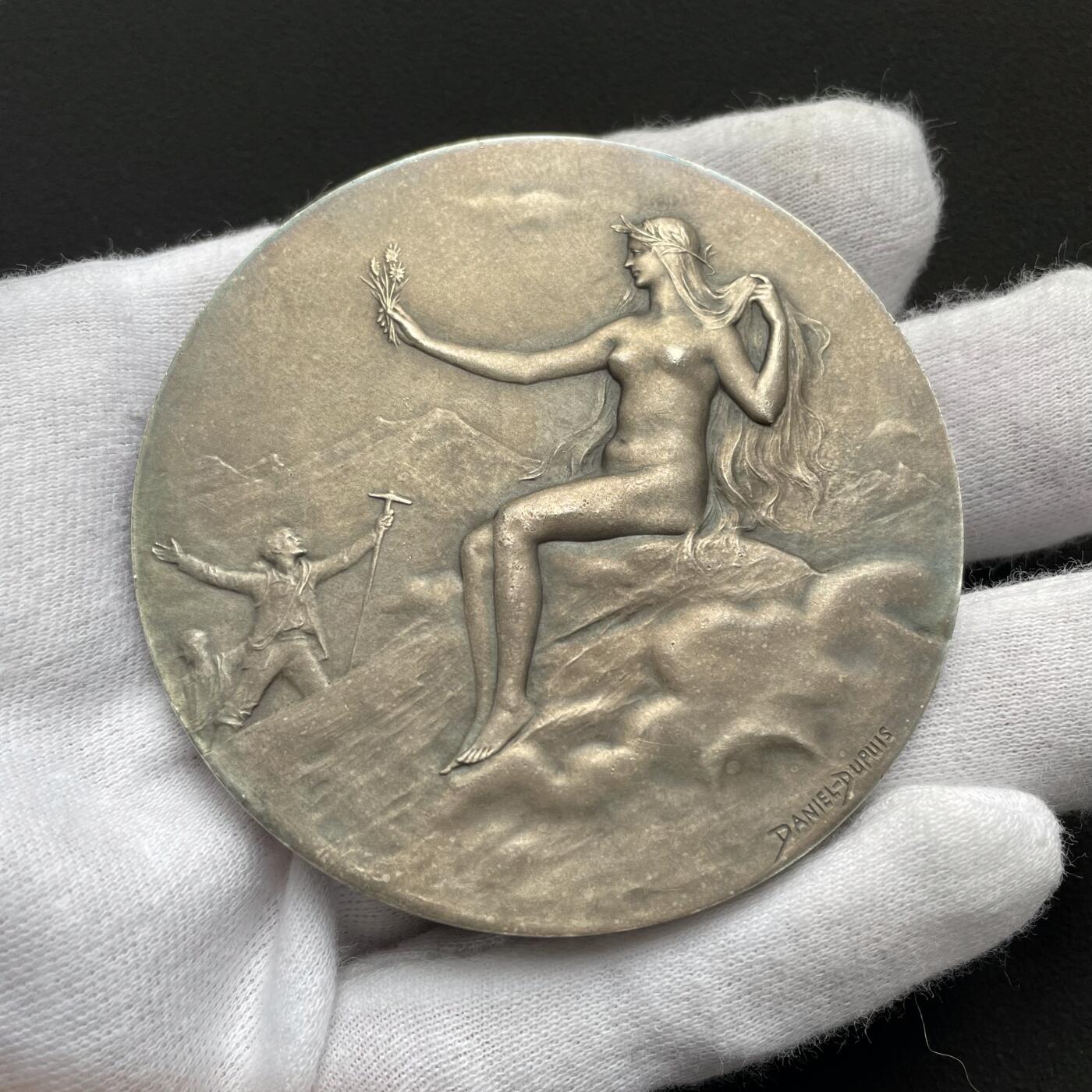 「木头集藏」“ 新岁撷珍”——章牌精品专场！ D.Dupuis～法国阿尔卑斯登山俱乐部大银章，直径: 64mm，124.5 g，  边铭: 丰饶角1ARGENT ，法国阿尔卑斯登山俱乐部赠乔治·布贝先生，正面：头戴桂冠的女神坐在云层上的高山之巅，手持一束阿尔卑斯山的名花——雪绒花，向张开双臂欢呼胜利登顶的登山者们致以欢迎之意。背面：饰以棕榈枝、登山杖、登山镐和绳索的羊皮纸题笺。 边缘一处很轻微的锉痕。少见银章，上手感觉更佳！