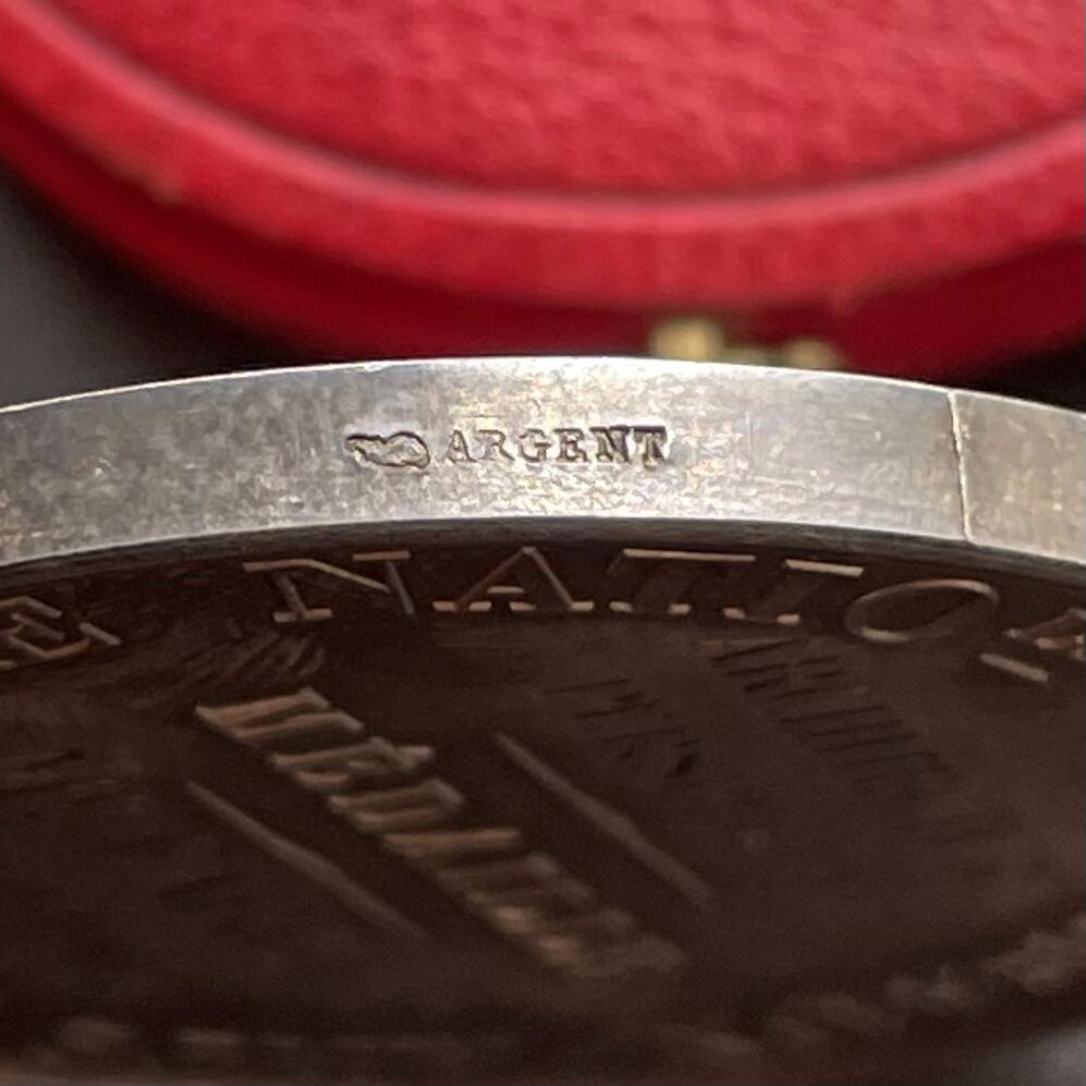 「木头集藏」“ 新岁撷珍”——章牌精品专场！ 1902年法国巴黎国立高等美术学院原盒银章，直径：41 mm，37 g，边铭：丰饶角 ARGENT，三位女性分别代表雕塑（手持锤子与凿子）、建筑（手持标尺与绘图工具）、绘画（手持调色板与画笔）。 左侧小雕像为智慧女神密涅瓦（Minerva），代表艺术创作的理性与灵感。品相不错，彩色氧化很美，原盒正常使用，同款收藏佳品。