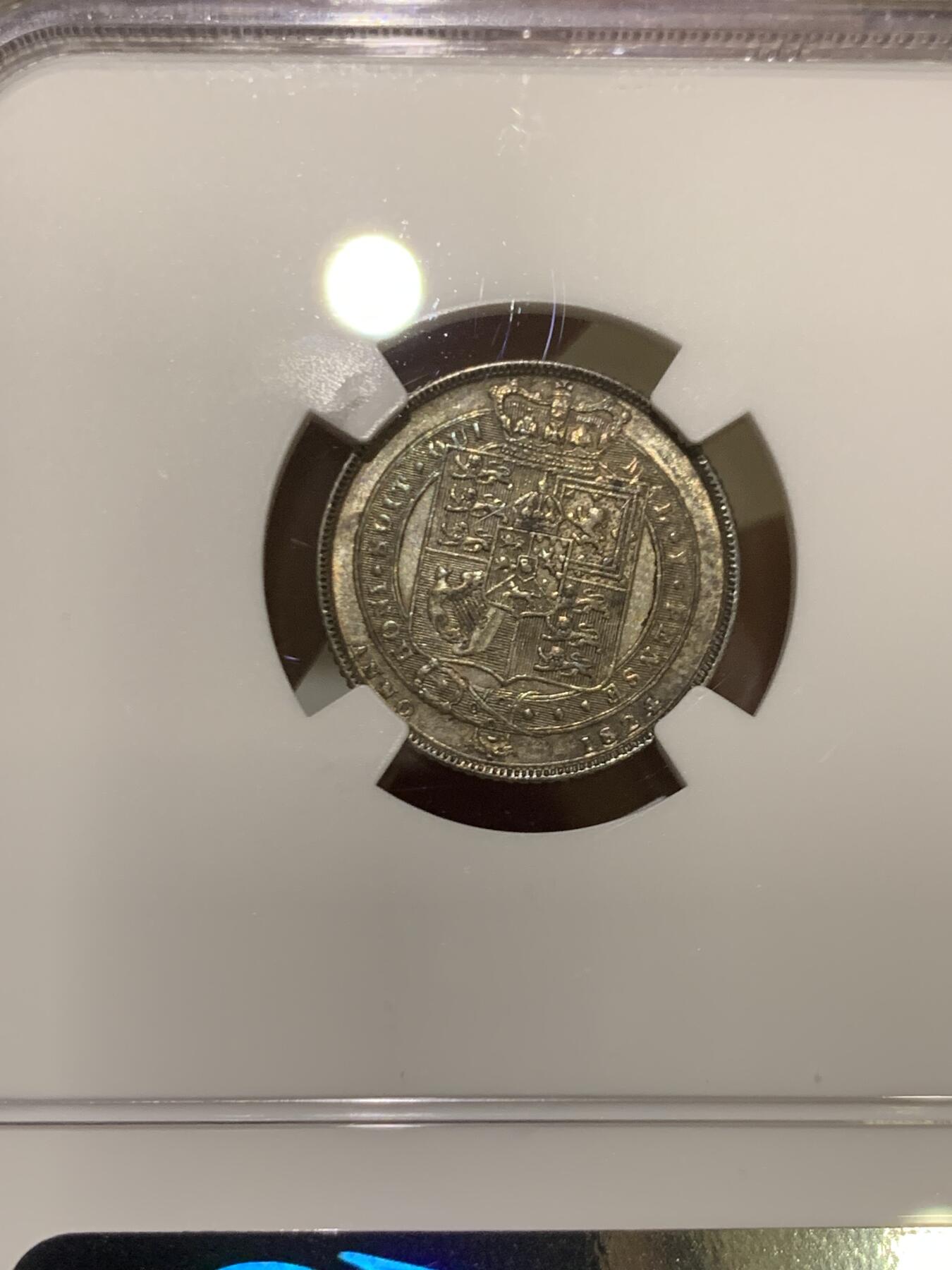 《竞宝斋》第464场 周日，周一，周二，3场连拍 （全场包邮）欢迎送拍 NGC MS62 英国1824年乔治四世国王6便士银币，铸造于英国皇家造币厂，正面有明显的镜面感以及蓝调包浆，非常漂亮，背面灰色包浆，细节完整。整体非常舒服。