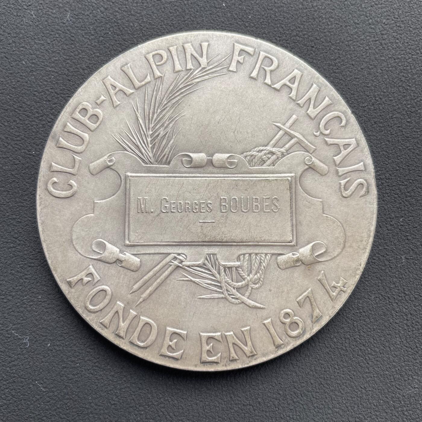 「木头集藏」“ 新岁撷珍”——章牌精品专场！ D.Dupuis～法国阿尔卑斯登山俱乐部大银章，直径: 64mm，124.5 g，  边铭: 丰饶角1ARGENT ，法国阿尔卑斯登山俱乐部赠乔治·布贝先生，正面：头戴桂冠的女神坐在云层上的高山之巅，手持一束阿尔卑斯山的名花——雪绒花，向张开双臂欢呼胜利登顶的登山者们致以欢迎之意。背面：饰以棕榈枝、登山杖、登山镐和绳索的羊皮纸题笺。 边缘一处很轻微的锉痕。少见银章，上手感觉更佳！