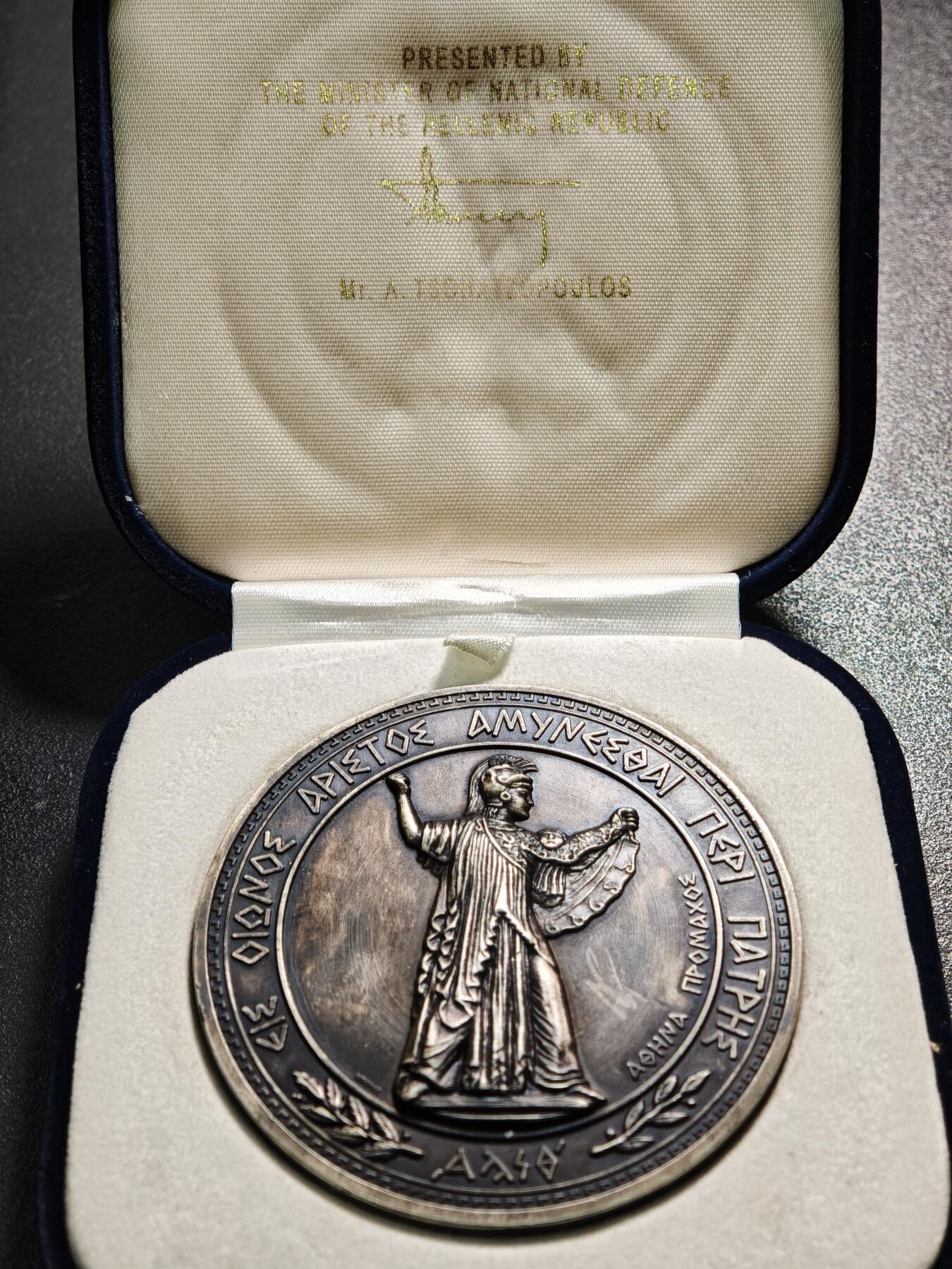 【德藏】世界币章拍卖第164期（拍品征集中~欢迎藏友联系） 20世纪初希腊国防部纪念大银章  直径约：70.3mm；重约：156.1g 欧洲黑包浆，雕刻精美，原装盒子，收藏价值高。正面是头戴战盔、身披长袍的古希腊神话中智慧、战争与守护女神雅典娜的站立像；背面中间是装饰有希腊国徽、海锚、头盔、交叉的箭头等元素的盾牌，盾牌上方文字是希腊语“ΑΜΥΝΕΣΘΑΙ ΠΕΡΙ ΠΑΤΡΗΣ（为祖国而战）”