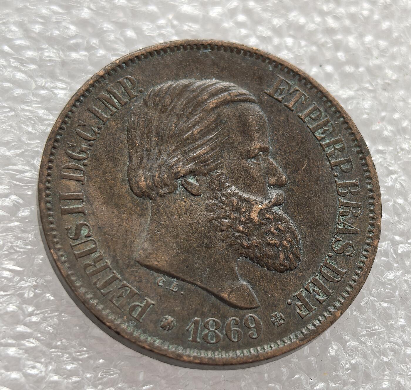 外国优质老铜币高银银币，周六九点倒数截拍，满百包邮，持续收拍，年后发货 巴西帝国 1869 年20 瑞斯铜币，属于佩德罗二世统治时期，正值巴拉圭战争后期。它见证了巴西帝国鼎盛阶段的货币体系，铜币的发行既满足了战时经济流通需求，也反映了帝国的政治权威与经济特征。