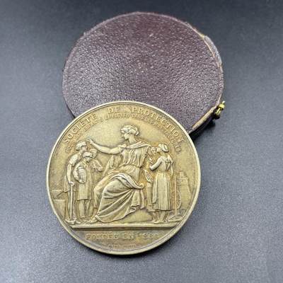 「木头集藏」“ 新岁撷珍”——章牌精品专场！ - A.Dubois～1901年法国童工保护协会原盒镀金银章，直径：45 mm，50.4 g，边铭：丰饶角 ARGENT，名家作品，正面刻画手持工具、衣着朴素的童工，右侧是手持纺轮的女工，背景还有工厂设备，生动再现了19世纪法国工厂的童工处境。较少见银章，品相不错，原盒正常使用。