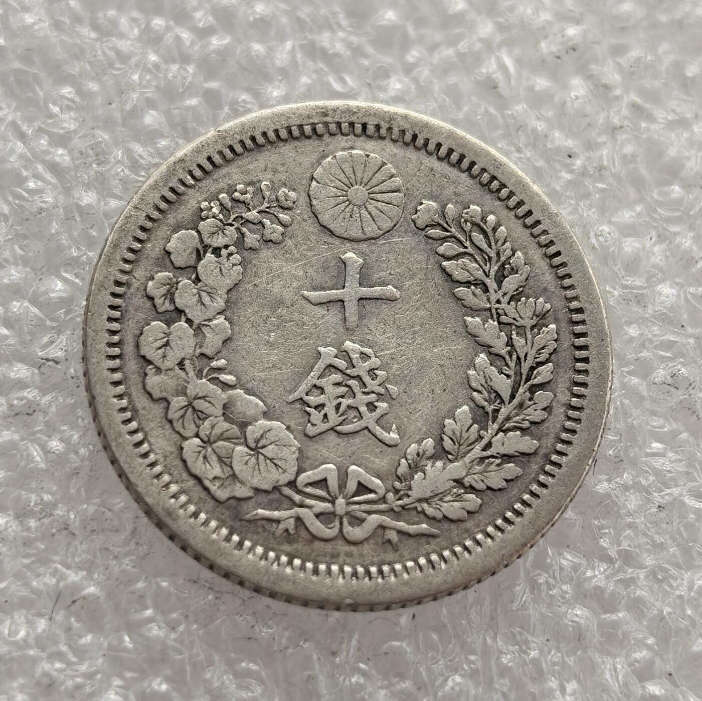 外国优质老铜币高银银币，周六九点倒数截拍，满百包邮，持续收拍，年后发货 日本明治八年（1875 年）  十钱银币，属于明治维新时期的流通货币。币面的龙纹与菊花纹章，是日本近代化转型的象征，反映了当时日本学习西方货币制度、推动经济工业化的努力，是明治维新后货币体系改革的重要见证。