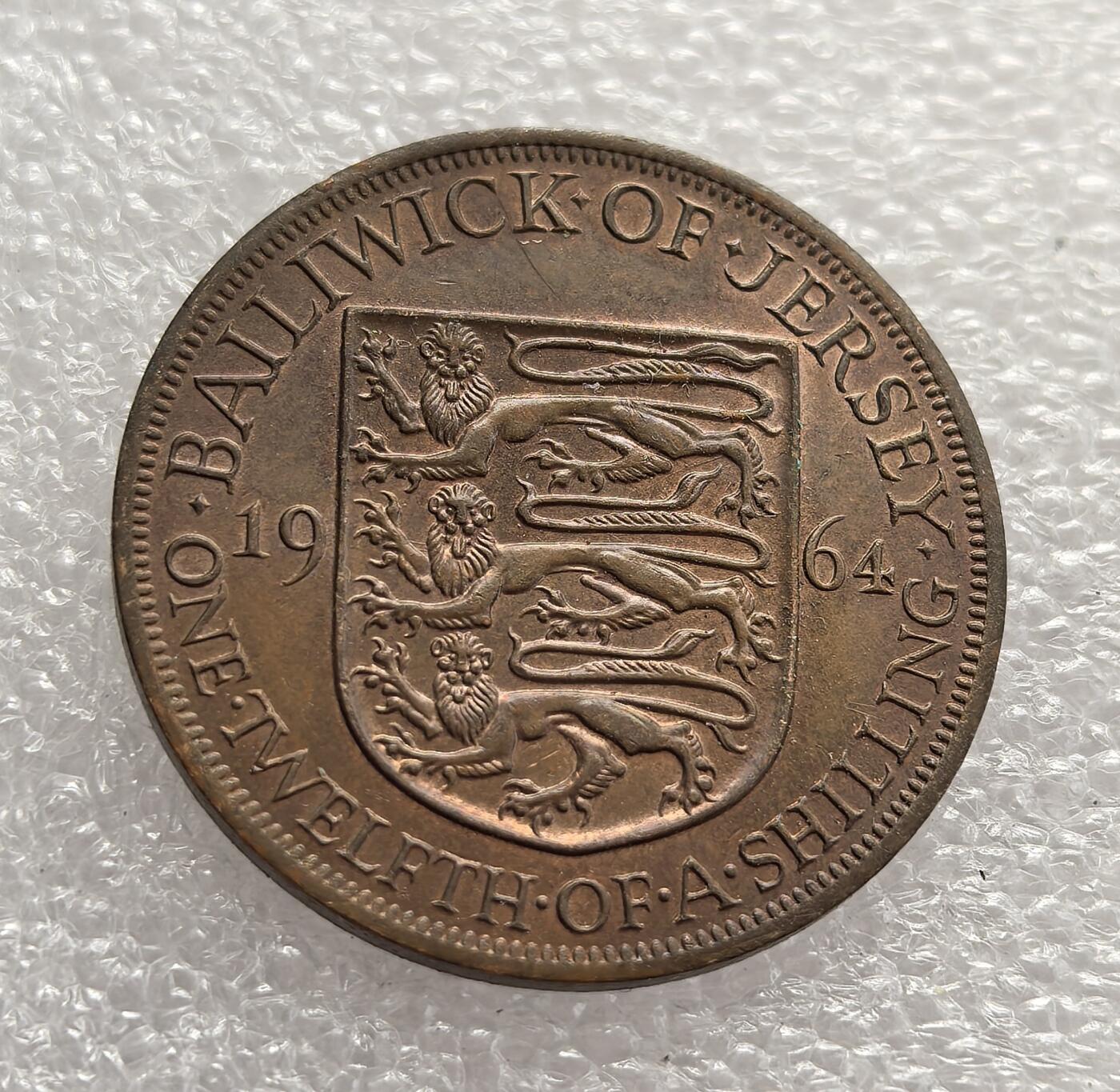 外国优质老铜币高银银币，周六九点倒数截拍，满百包邮，持续收拍，年后发货 英国皇家属地泽西行政区1964年 1/12 先令铜币。币面的皇家盾徽与女王头像体现了英联邦属地的货币特征，见证了战后泽西岛延续英国货币体系、维系殖民关联的历史。