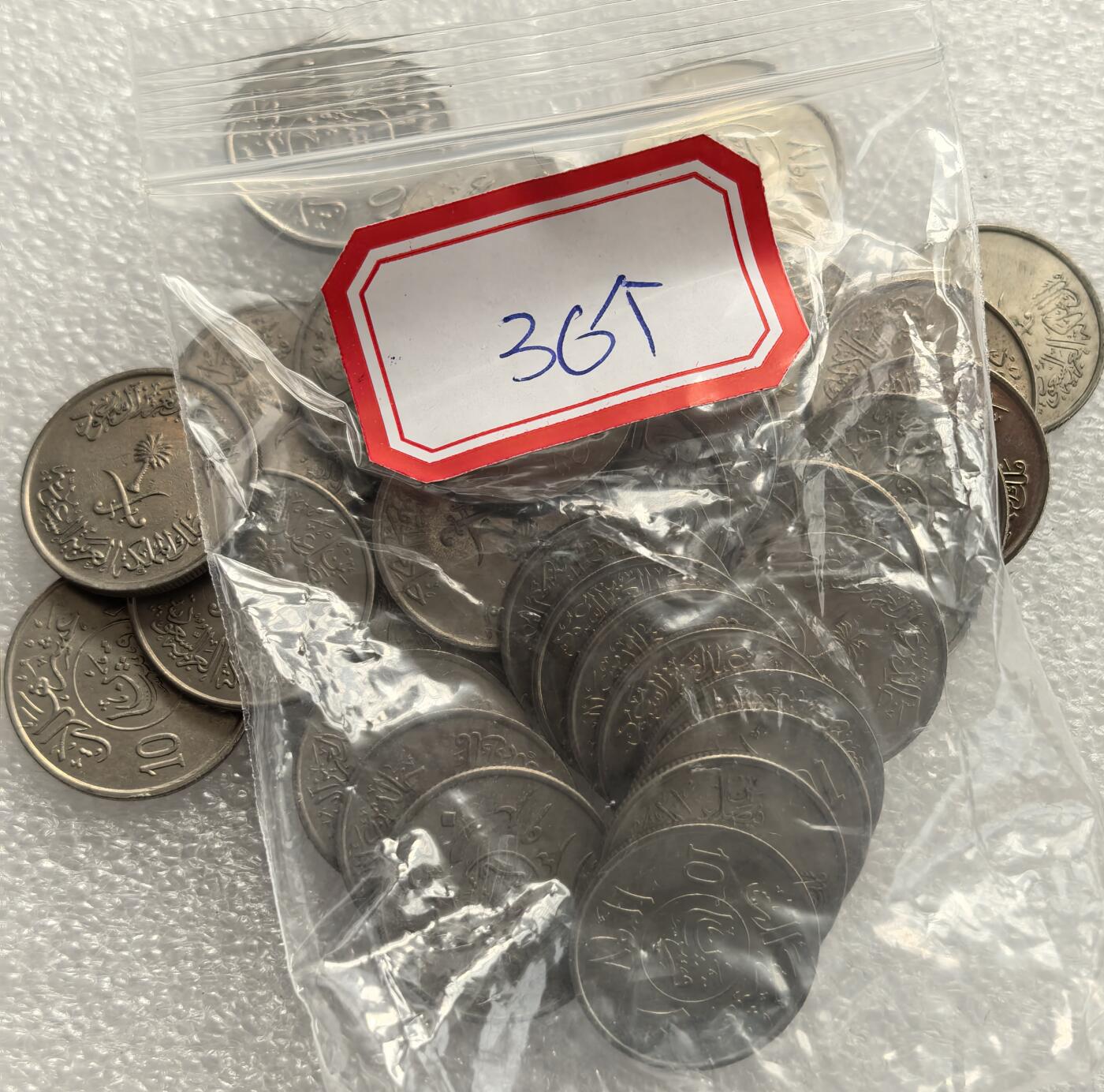 外国优质老铜币高银银币，周六九点倒数截拍，满百包邮，持续收拍，年后发货 沙特阿拉伯王国10哈啦啦36枚，正面铸沙特国徽（椰枣树与交叉佩剑）及阿拉伯文宗教、国名铭文，融合伊斯兰文化与国家象征，见证沙特建国后货币体系统一与国家身份的货币呈现。