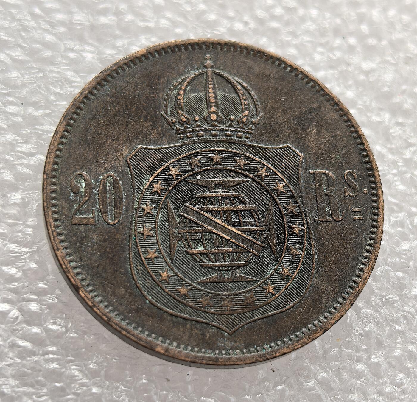 外国优质老铜币高银银币，周六九点倒数截拍，满百包邮，持续收拍，年后发货 巴西帝国 1869 年20 瑞斯铜币，属于佩德罗二世统治时期，正值巴拉圭战争后期。它见证了巴西帝国鼎盛阶段的货币体系，铜币的发行既满足了战时经济流通需求，也反映了帝国的政治权威与经济特征。