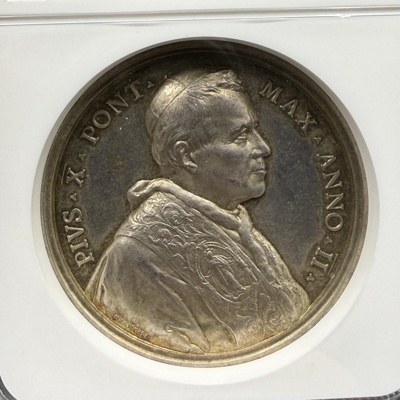 「木头集藏」“ 新岁撷珍”——章牌精品专场！ 1904年梵蒂冈教皇庇护十世封圣纪念银章，MS 62 ，直径：44 mm，展现了两位被封圣的圣人（圣萨维利与圣马泰兰）立于云端的场景，上方是象征圣灵的放射状白鸽，底部可见圣彼得大教堂穹顶的轮廓。 边缘铭文为A SAVLI ET G MATELLAN SANCTORVM HONORES DECRETI，对应1904年庇护十世主持的封圣仪式。