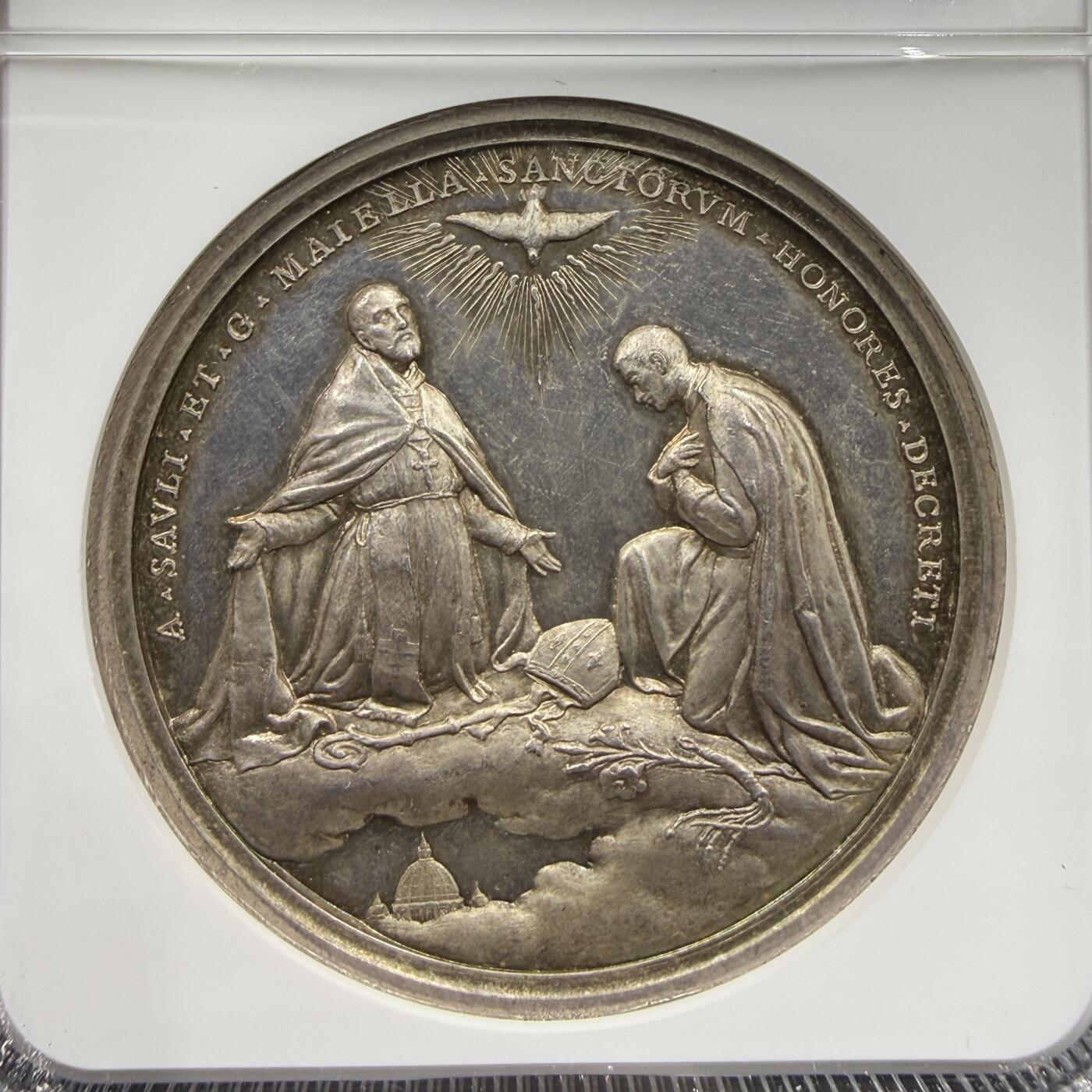 「木头集藏」“ 新岁撷珍”——章牌精品专场！ 1904年梵蒂冈教皇庇护十世封圣纪念银章，MS 62 ，直径：44 mm，展现了两位被封圣的圣人（圣萨维利与圣马泰兰）立于云端的场景，上方是象征圣灵的放射状白鸽，底部可见圣彼得大教堂穹顶的轮廓。 边缘铭文为A SAVLI ET G MATELLAN SANCTORVM HONORES DECRETI，对应1904年庇护十世主持的封圣仪式。