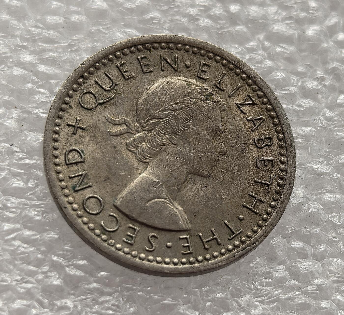 外国优质老铜币高银银币，周六九点倒数截拍，满百包邮，持续收拍，年后发货 新西兰 1965 年3 便士流通硬币，属于伊丽莎白二世时期英联邦货币体系下的旧制货币，是 1967 年新西兰货币十进制改革前的最后一批流通币之一。币面毛利战棍设计融合本土文化与殖民象征，见证了新西兰在英联邦框架下的文化身份构建。