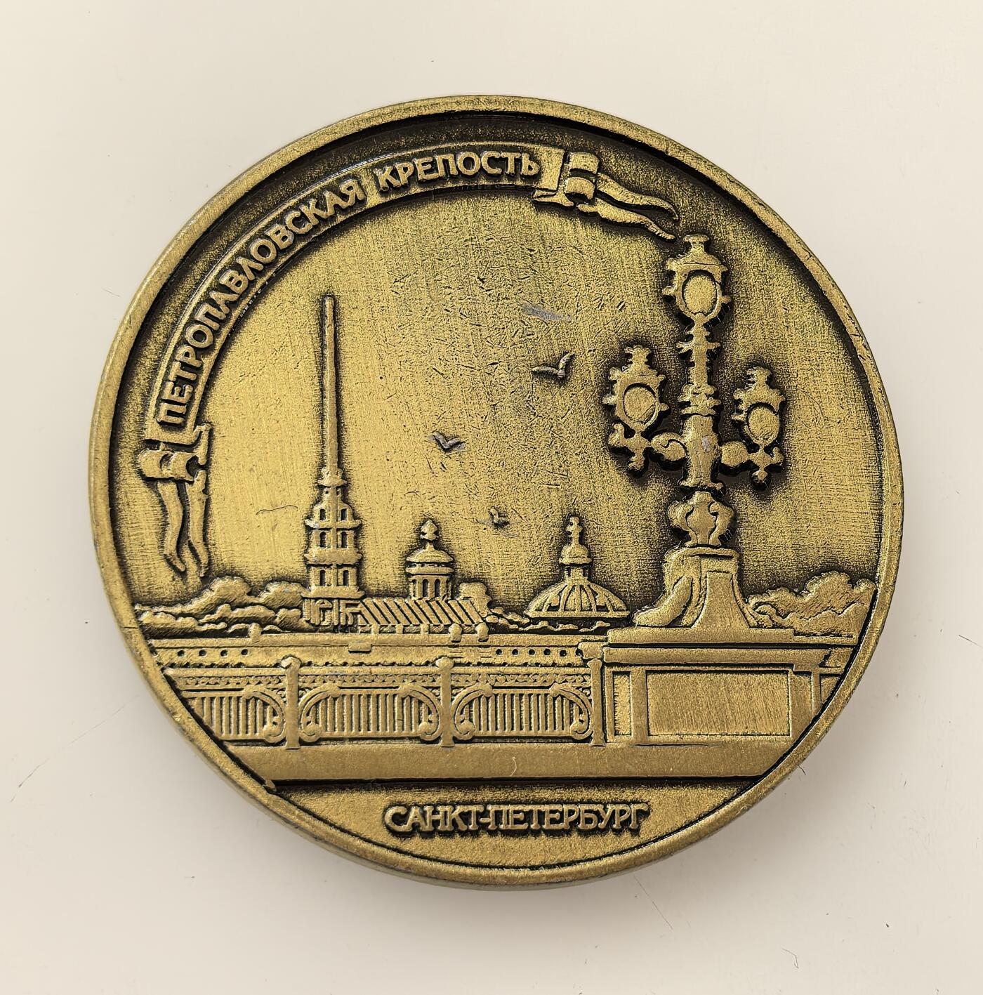 外国优质老铜币高银银币，周六九点倒数截拍，满百包邮，持续收拍，年后发货 圣彼得堡彼得保罗要塞的黄铜质纪念章，该要塞 1703 年由彼得一世下令修建，是圣彼得堡的起源地与沙俄军事政治象征，承载着城市建城与沙俄早期历史记忆。