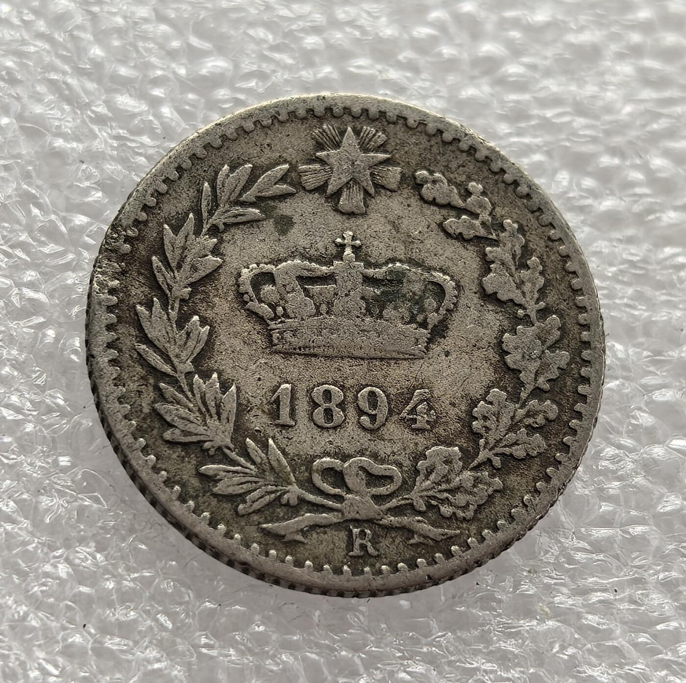 外国优质老铜币高银银币，周六九点倒数截拍，满百包邮，持续收拍，年后发货 意大利王国 1894 年20 分，属于翁贝托一世统治时期的流通货币。当时意大利正处于工业革命与殖民扩张的起步阶段，该币以皇冠与花环为设计，象征王权与国家稳定，见证了意大利近代化进程中的货币体系建设。