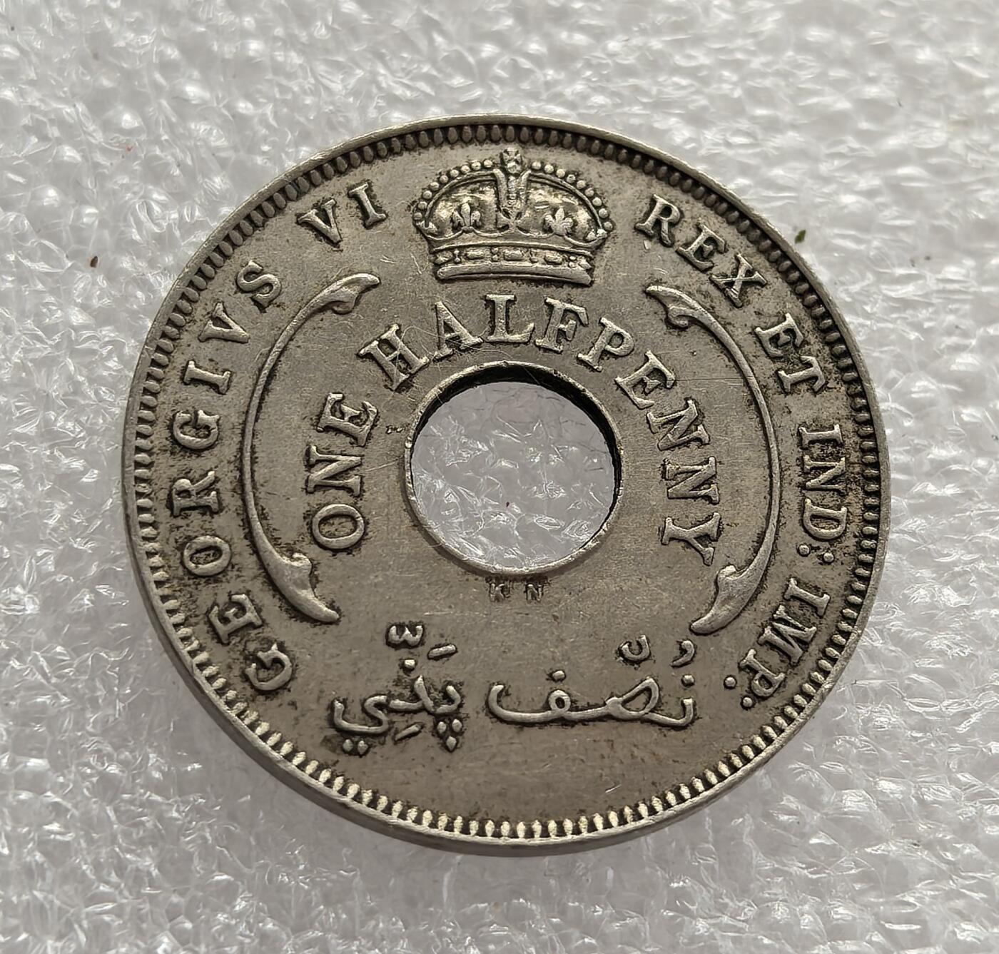 外国优质老铜币高银银币，周六九点倒数截拍，满百包邮，持续收拍，年后发货 英属西非 1937 年半便士流通硬币，正值乔治六世继位初期。币面六芒星是西非殖民货币的标志性图案，中间圆孔是小额硬币的典型设计，阿拉伯文适配西非穆斯林文化，见证了英国殖民统治下的货币统一与文化适配。