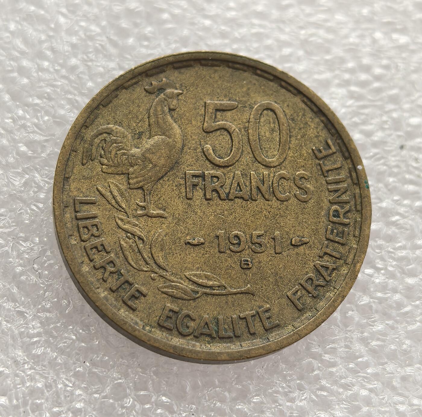 外国优质老铜币高银银币，周六九点倒数截拍，满百包邮，持续收拍，年后发货 法国 1951 年50 法郎铜币B版，属于法兰西第四共和国时期的流通货币。当时法国正处于战后经济重建与社会复苏阶段，该币以象征法国民族精神的高卢雄鸡与玛丽安娜头像为设计，见证了战后法国货币体系的稳定与国家认同的延续。