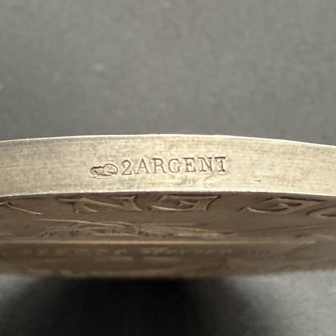 「木头集藏」“ 新岁撷珍”——章牌精品专场！ D.Dupuis～法国阿尔卑斯登山俱乐部大银章，直径: 64mm，124.5 g，  边铭: 丰饶角1ARGENT ，法国阿尔卑斯登山俱乐部赠乔治·布贝先生，正面：头戴桂冠的女神坐在云层上的高山之巅，手持一束阿尔卑斯山的名花——雪绒花，向张开双臂欢呼胜利登顶的登山者们致以欢迎之意。背面：饰以棕榈枝、登山杖、登山镐和绳索的羊皮纸题笺。 边缘一处很轻微的锉痕。少见银章，上手感觉更佳！