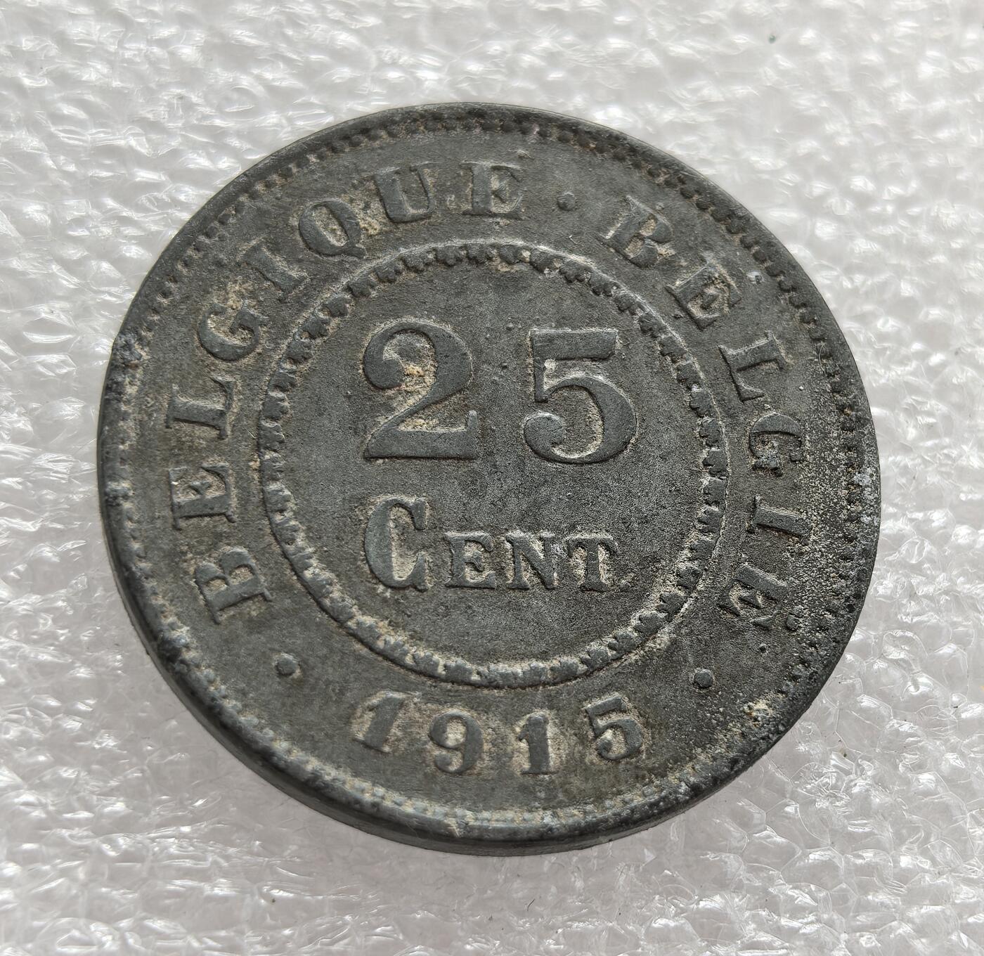 外国优质老铜币高银银币，周六九点倒数截拍，满百包邮，持续收拍，年后发货 比利时 1915 年25 分锌质硬币，正值一战期间比利时被德国占领的特殊时期。因战争导致铜、银等金属资源匮乏，锌作为廉价替代材质被用于铸币，币面的雄狮图案延续了比利时国徽元素，见证了战时经济困境与国家身份的维系。