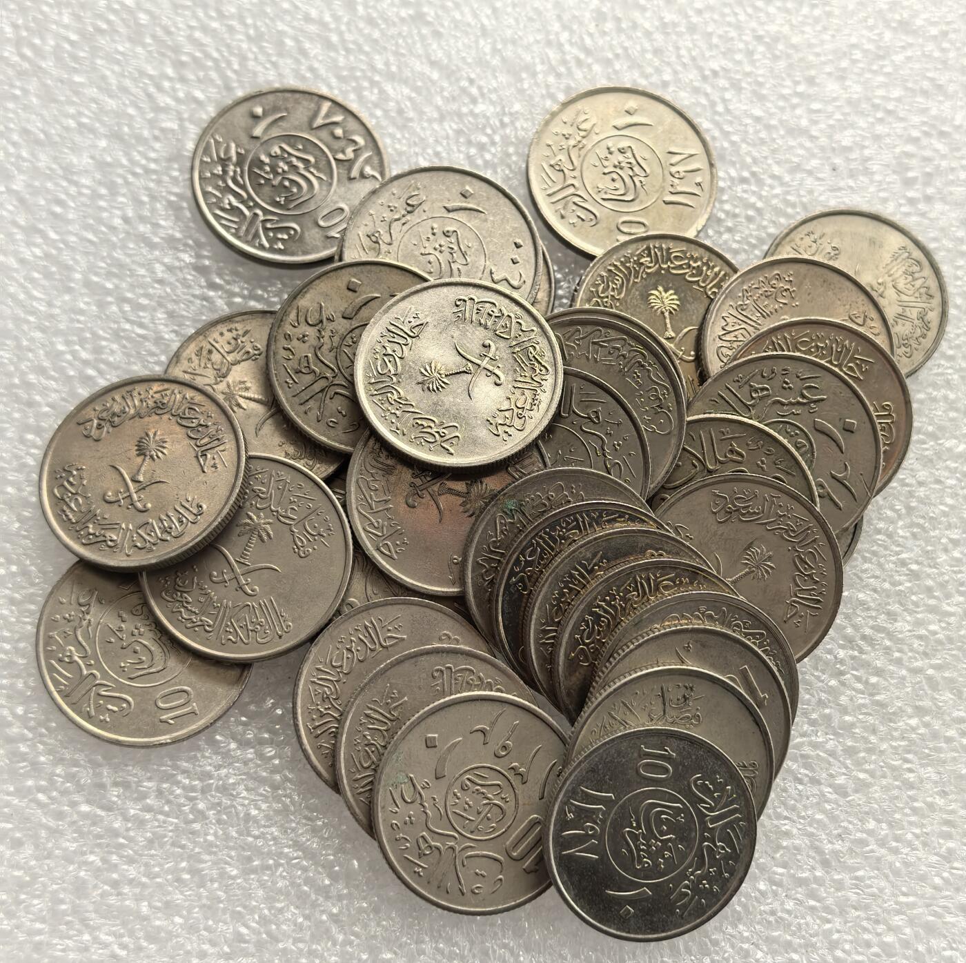 外国优质老铜币高银银币，周六九点倒数截拍，满百包邮，持续收拍，年后发货 沙特阿拉伯王国10哈啦啦36枚，正面铸沙特国徽（椰枣树与交叉佩剑）及阿拉伯文宗教、国名铭文，融合伊斯兰文化与国家象征，见证沙特建国后货币体系统一与国家身份的货币呈现。