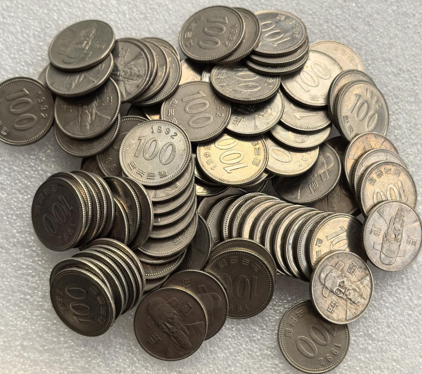 外国优质老铜币高银银币，周六九点倒数截拍，满百包邮，持续收拍，年后发货 韩国  100 韩元100枚（1992 年版），正面铸面额 “100” 与韩文标识，背面为朝鲜王朝抗倭名将李舜臣头像，属韩国现行主流流通货币，融合历史人物纪念与现代货币功能，见证韩国货币文化的传承与实用属性。