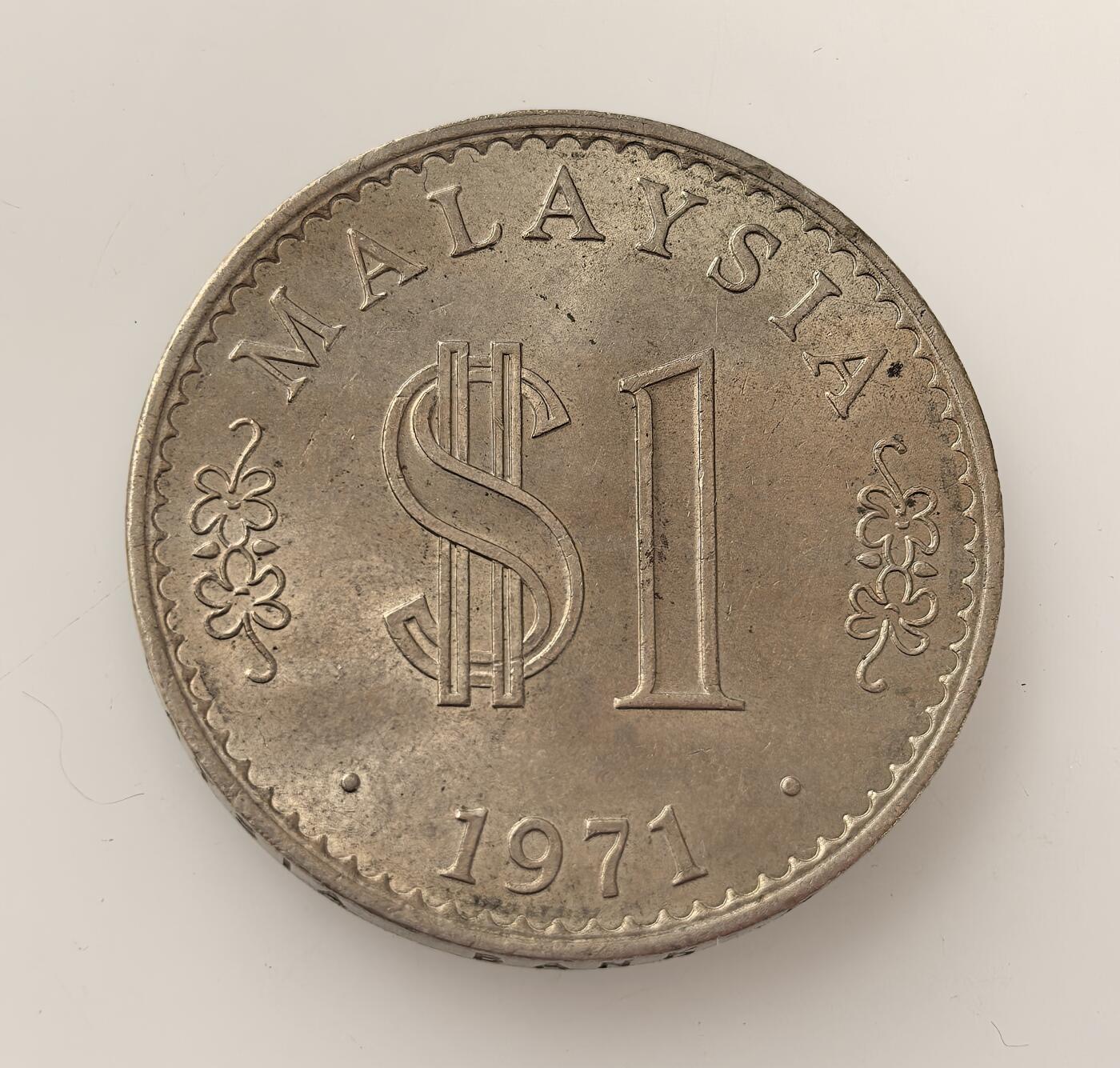 外国优质老铜币高银银币，周六九点倒数截拍，满百包邮，持续收拍，年后发货 1971 年马来西亚   1 林吉特硬币，属马来西亚独立后早期流通货币，背面铸国会大厦、星月及 14 角星（象征 13 州与联邦），彰显国家主权与发展，见证马来西亚货币体系的构建历程。