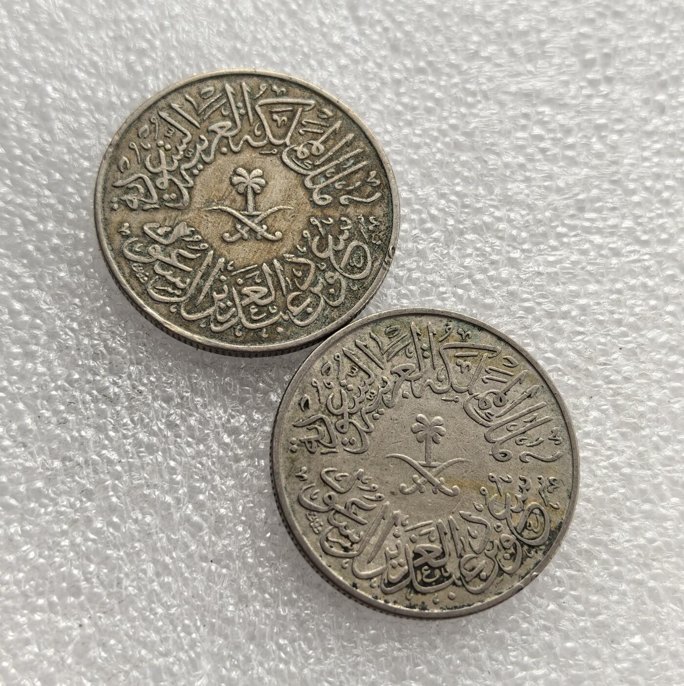 外国优质老铜币高银银币，周六九点倒数截拍，满百包邮，持续收拍，年后发货 沙特阿拉伯王国4 哈拉拉2枚，对应伊斯兰历 1376 年（公历 1956-1957 年），正面铸沙特国徽（椰枣树与交叉佩剑）及阿拉伯文铭文，背面为面额与伊斯兰历纪年，见证沙特建国后货币体系统一与国家象征的货币呈现。