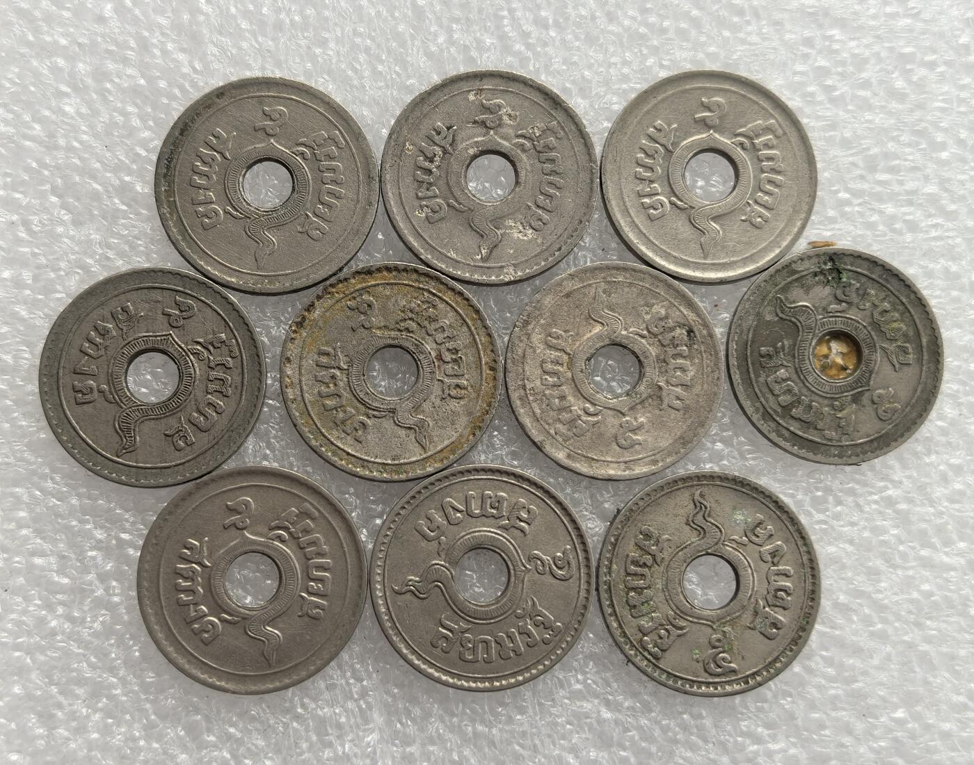 外国优质老铜币高银银币，周六九点倒数截拍，满百包邮，持续收拍，年后发货 20 世纪早中期泰国  中孔小额辅币（多为 1 萨当）10枚，正面铸泰文面额与本土神话那伽（蛇神）图腾，背面为螺旋纹饰，中孔形制受东方钱币文化影响，融合佛教文化，见证泰国货币体系近代化进程。