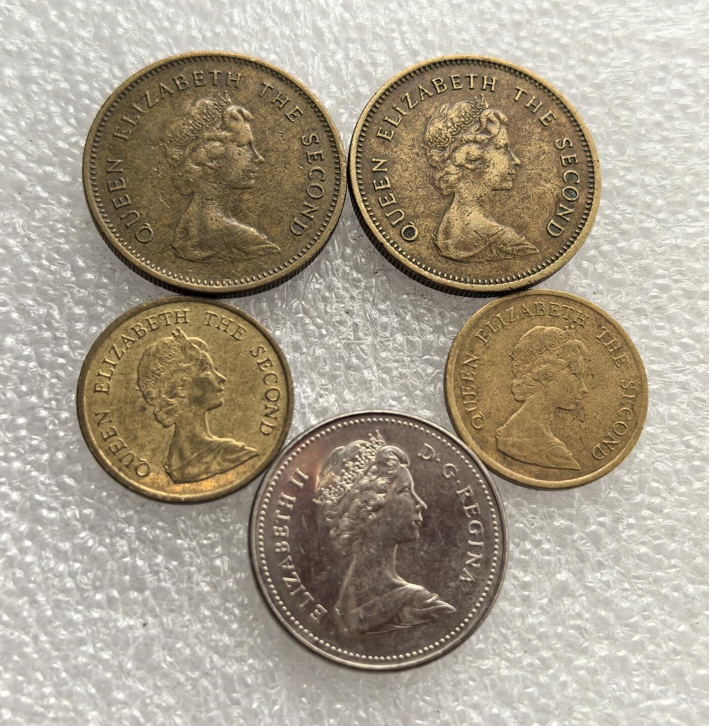 外国优质老铜币高银银币，周六九点倒数截拍，满百包邮，持续收拍，年后发货 20 世纪 70-80 年代英联邦地区流通辅币，含香港伍毫、10 分与加拿大 5 分硬币。正面铸伊丽莎白二世头像，体现英联邦殖民 / 自治领属性；香港币属港元体系，加拿大币以河狸为图案，见证殖民时期货币与英联邦文化印记。
