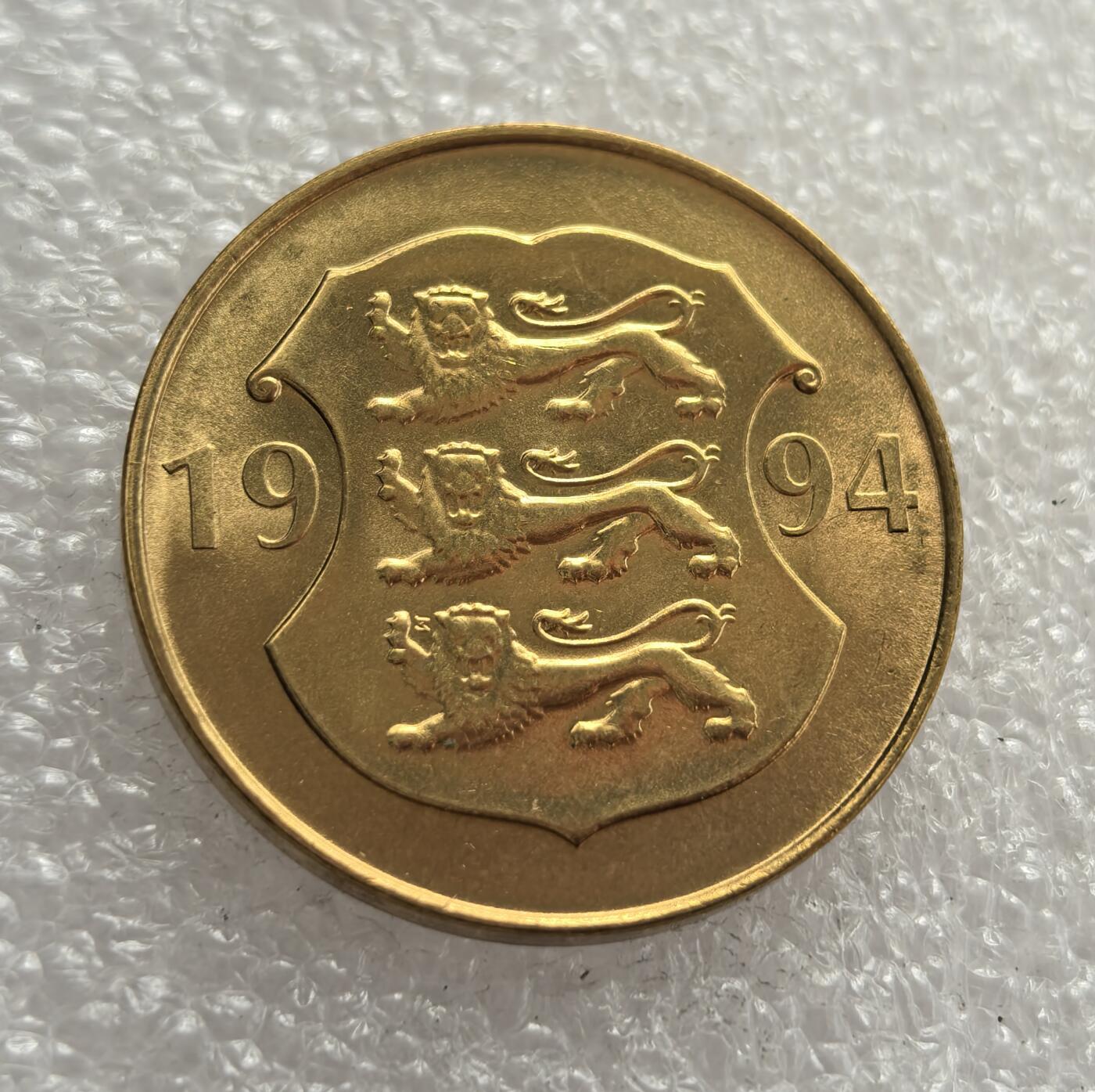 外国优质老铜币高银银币，周六九点倒数截拍，满百包邮，持续收拍，年后发货 爱沙尼亚1994年5克朗纪念币，纪念爱沙尼亚银行成立 75 周年，正值 1991 年独立后的经济重建阶段。币面国徽三头狮子象征主权，抽象建筑图案呼应金融主题，见证了该国独立后的货币与金融发展。