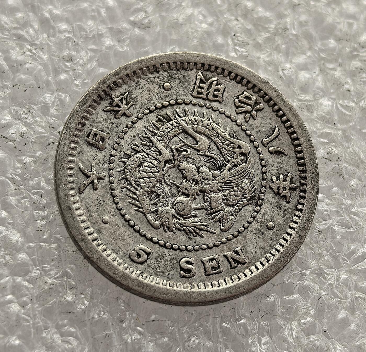 外国优质老铜币高银银币，周六九点倒数截拍，满百包邮，持续收拍，年后发货 日本明治八年（1875 年）  五钱银币，是明治维新时期的流通货币。币面龙纹与菊花纹章的设计，体现了日本近代化转型中融合传统与西方的理念，见证了当时日本建立统一货币体系、推动经济工业化的进程。