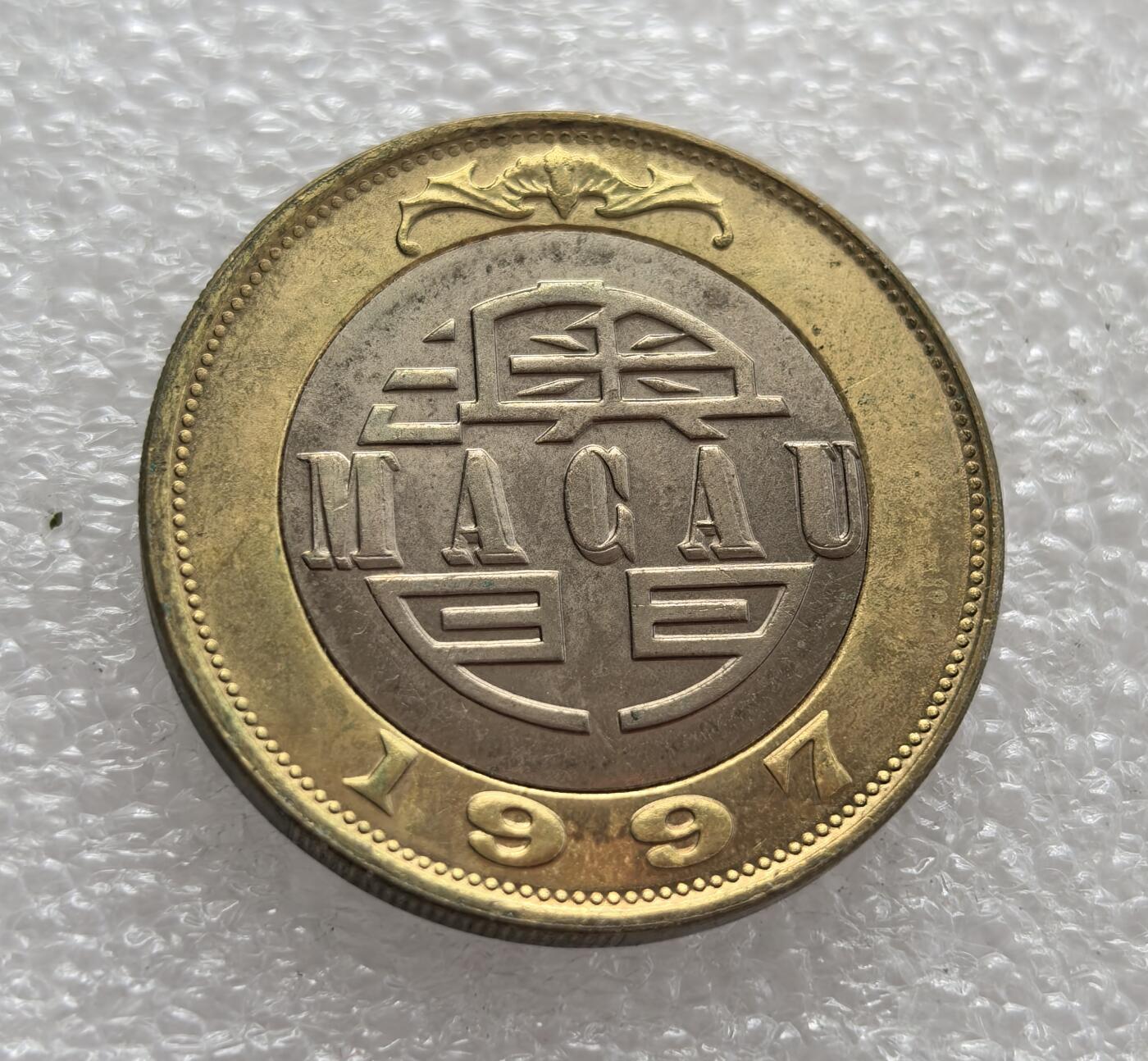外国优质老铜币高银银币，周六九点倒数截拍，满百包邮，持续收拍，年后发货 葡属澳门1997 年10 元双色流通硬币，正值回归前的过渡阶段。币面大三巴牌坊是澳门标志性建筑，背面 “澳门” 字样与蝙蝠吉祥图案，见证了澳门回归前的货币体系与文化特征。