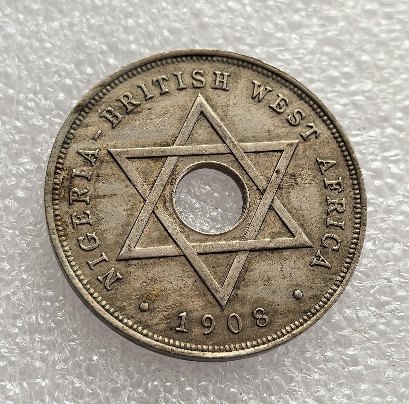 外国优质老铜币高银银币，周六九点倒数截拍，满百包邮，持续收拍，年后发货 英属西非（尼日利亚）1908 年1 便士流通硬币，属于爱德华七世统治时期。币面六芒星是西非殖民货币标志性图案，中间圆孔为小额硬币典型设计，阿拉伯文适配本土文化，见证了英国殖民统治下的货币整合与文化适配。