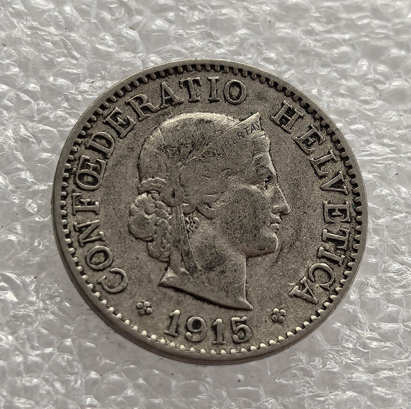 外国优质老铜币高银银币，周六九点倒数截拍，满百包邮，持续收拍，年后发货 瑞士联邦 1915 年   5 分，正值一战期间。当时瑞士保持中立，经济稳定，币面的海尔维蒂亚女神头像象征国家身份，三叶草花环延续传统设计，见证了中立国在动荡时局中的货币体系稳固