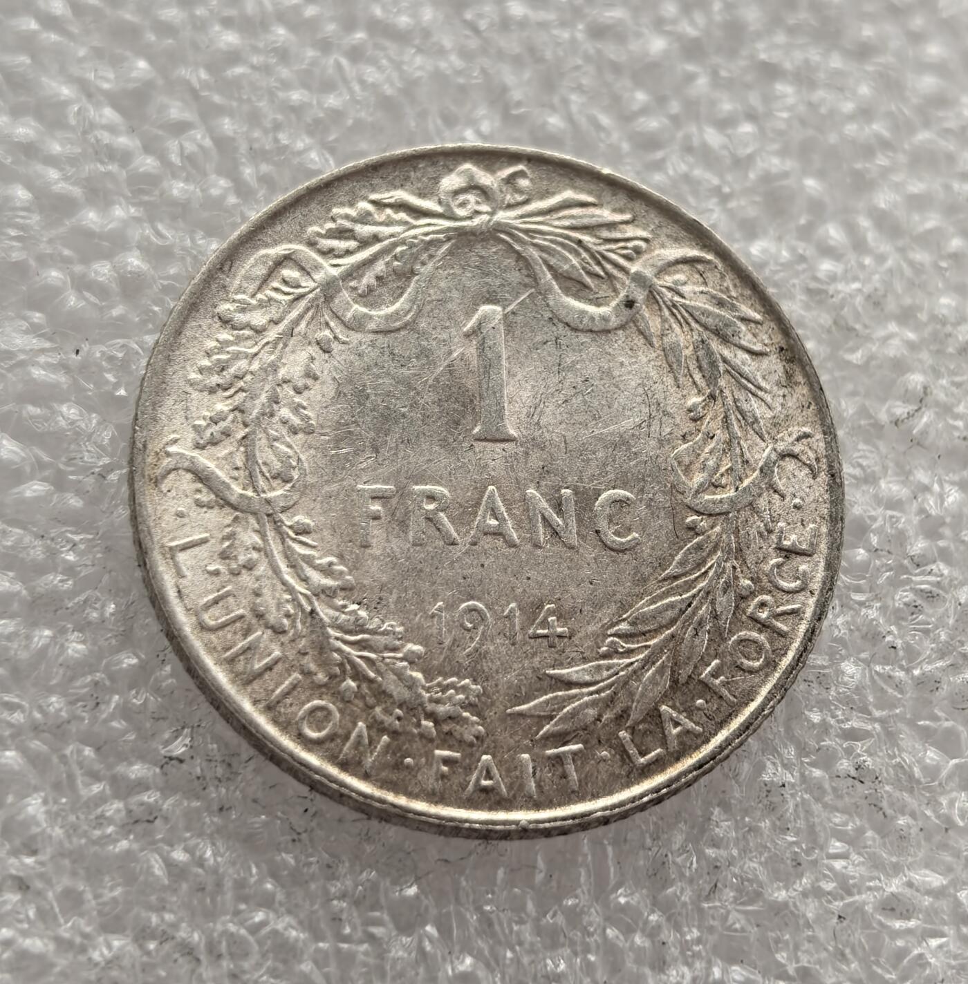 外国优质老铜币高银银币，周六九点倒数截拍，满百包邮，持续收拍，年后发货 比利时 1914 年 1 法郎银币，属于阿尔贝一世在位时期的流通货币。当时一战爆发，比利时虽遭德军入侵但仍坚守中立象征，该币以国王头像与 “团结就是力量” 格言为设计，是战时比利时维系国家精神与货币体系的见证。