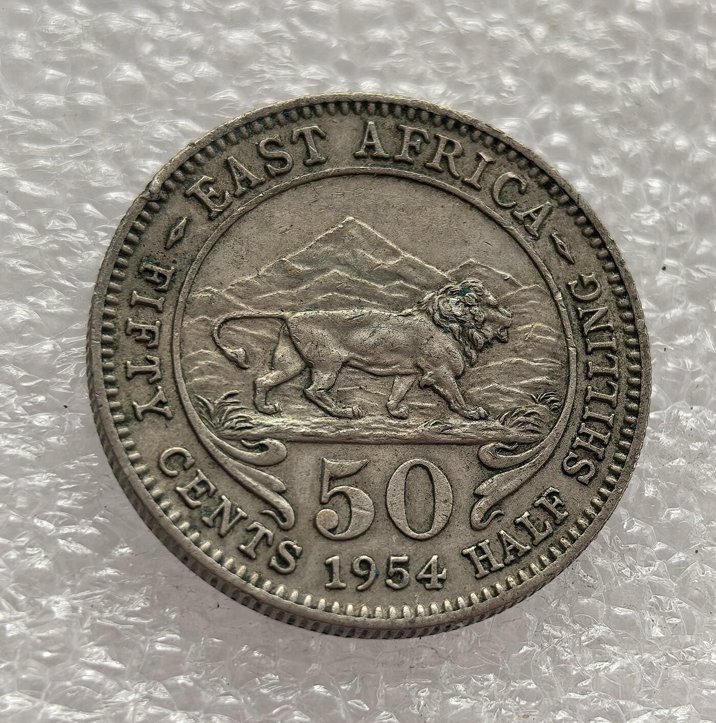 外国优质老铜币高银银币，周六九点倒数截拍，满百包邮，持续收拍，年后发货 英属东非 1954 年   50 分（半先令），属于伊丽莎白二世初期的货币。币面狮子与乞力马扎罗山的设计，见证了英国殖民统治末期东非的货币体系，也反映了战后非洲民族独立运动兴起前的殖民经济特征。