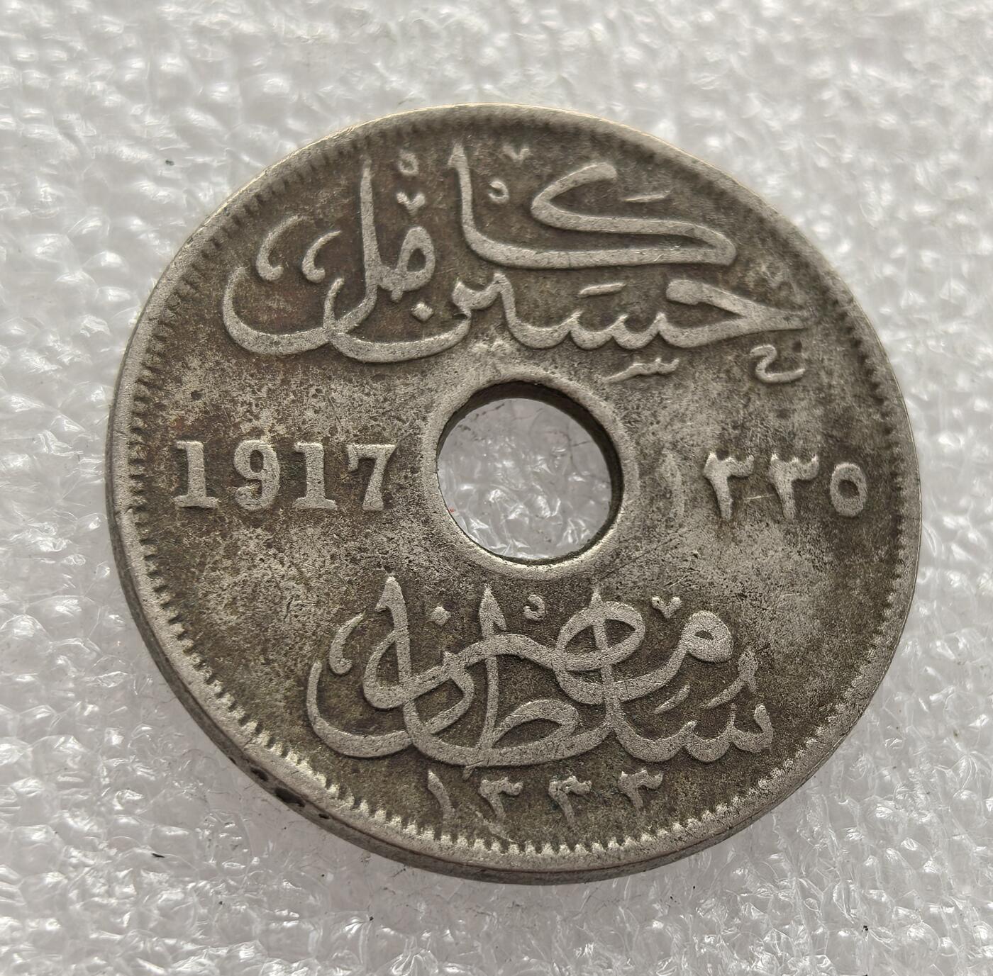外国优质老铜币高银银币，周六九点倒数截拍，满百包邮，持续收拍，年后发货 埃及 1917 年10 米利姆，正值英国保护国时期与第一次世界大战阶段。中间打孔的设计便于携带与计数，见证了殖民统治下埃及的战时货币体系与经济流通需求。