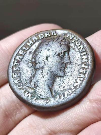  安东尼庇护塞斯特提大铜币，公元150-152年铸于罗马。背面年神Annona坐像，手持麦穗指向谷物桶Modius，并怀抱丰饶角。