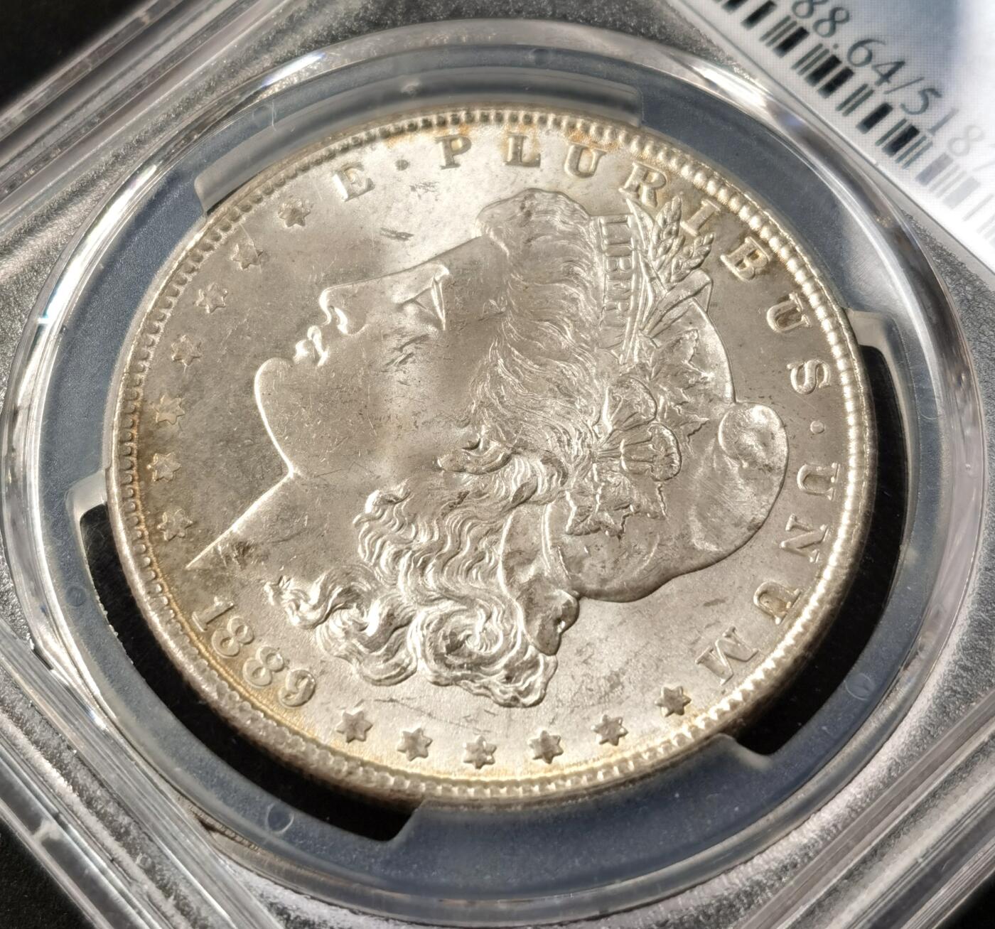 “福币呈祥”新年甄品场（直播拍卖）甄臻铺-世界币章拍卖（第50期），送拍享返佣金等优惠多多 PCGS-MS64 美国 1889年 摩根 银币 正面环彩带银霜 背面金彩带火烧云彩