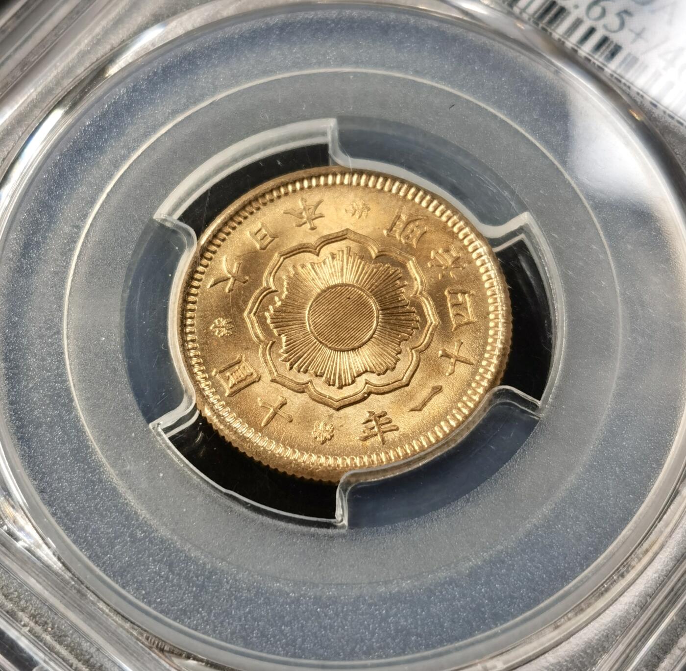 “福币呈祥”新年甄品场（直播拍卖）甄臻铺-世界币章拍卖（第50期），送拍享返佣金等优惠多多 PCGS-MS65+ 日本明治四十一年金拾元。此枚状态极佳，几乎看不见这个品种常见的蚂蚁脚划痕，光度状态已与66分无异。这个品种过了65分就是天价，此前博洋堂精品场65分已经过万，66分更是两次拍出近2万的天价，最近金价大涨背景下非常热门的品种。