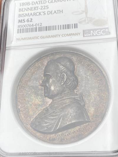 万国钱币拍卖第061期（马年首拍） NGC MS62 1863年梵蒂冈教皇国庇护九世纪念菲利波·德安杰利斯红衣主教在都灵的流放与被囚禁大银章 目录标注RR珍稀品种 背面拟人化的教皇国女神站在雄狮面前 完全不输“安娜与狮子”的顶级设计感 高浮雕极美孔雀蓝与晚霞彩渐变式七彩包浆 顶级收藏级品质 NGC标签错标为俾斯麦逝世