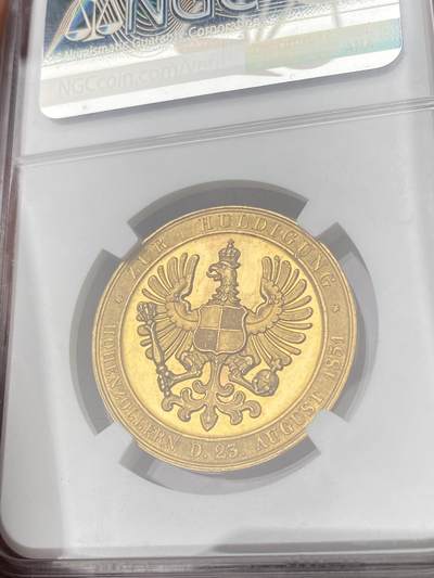 万国钱币拍卖第061期（马年首拍） NGC MS63 1851年德国霍亨索伦王室向普鲁士效忠纪念金章 1849年霍亨索伦-锡格马林根-黑兴根自愿放弃主权 宣誓效忠普鲁士 1850年三方皇室在霍亨索伦城堡举行领地世袭效忠仪式 威廉四世在仪式上将此章作为皇室赠礼赠送给相关成员 金质仅制作34枚 且其中有22枚作为通用版赠送 12枚作为国王荣誉礼赠 此种等级的金质品种在整个普鲁士章牌中都是翘楚般的存在 世间罕有的馆藏级古典艺术章牌藏品