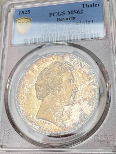 万国钱币拍卖第061期（马年首拍） PCGS MS62 1825年德国巴伐利亚路德维希一世加冕纪念历史大泰勒 历史泰勒系列开山之作 记录了国王路德维希一世登基加冕克承大统的重要时刻 路一身穿金丝镶边华服 颈戴十字架吊坠 左手握剑 右手持权杖 置于桌面的宪法之上 手边还有王冠一顶 金色色调彩光全深打浮雕喷砂质感 孔雀蓝环五彩点缀其中 德系历史泰勒名品收藏级