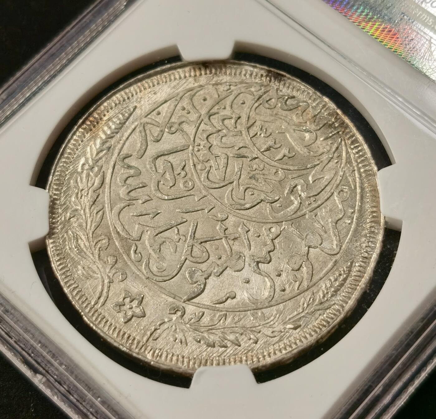 “福币呈祥”新年甄品场（直播拍卖）甄臻铺-世界币章拍卖（第50期），送拍享返佣金等优惠多多 NGC-MS66 也门1926年1里亚尔大银币，玫瑰金包浆，无敌光感，质感极佳。发行于也门穆塔瓦基利亚王国时期，是西亚钱币体系中极具代表性的经典品种。币面以伊斯兰传统阿拉伯铭文与缠枝花纹为核心设计，工艺繁复细腻，完美呈现了20世纪也门的宗教文化与货币铸造水准。