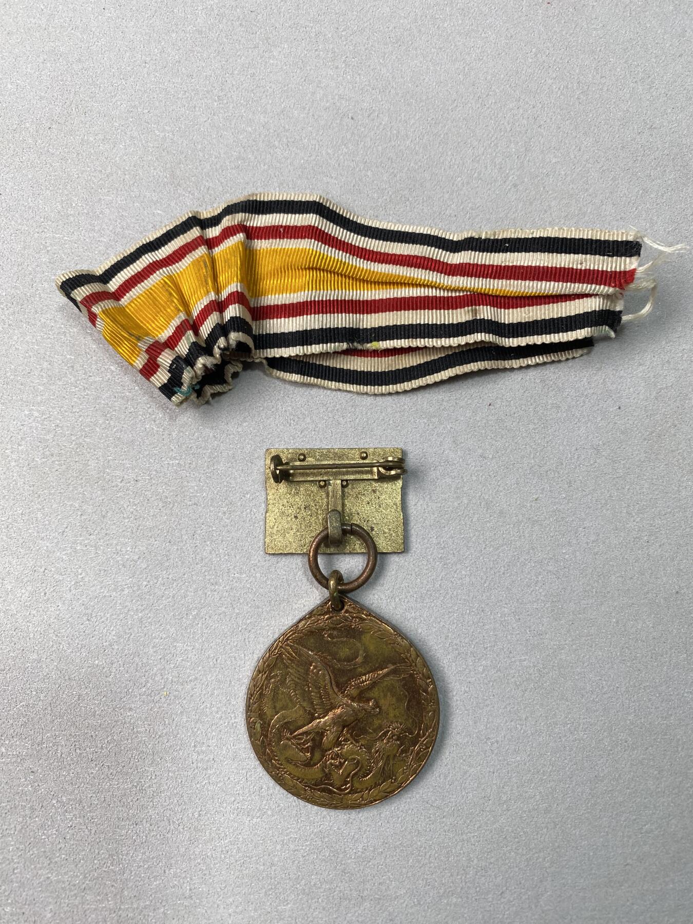 万国钱币拍卖第061期（马年首拍） 1900年德国庚子事变纪念铜制奖章 奖章奖励那些在帝德的东亚战争（八国联军侵华）中的英勇和坚韧行为 此枚带有原铸吊环和两道杠勋略以及原始勋带 红铜光保存极美可佩戴状态 22.9g（含吊环）32mm